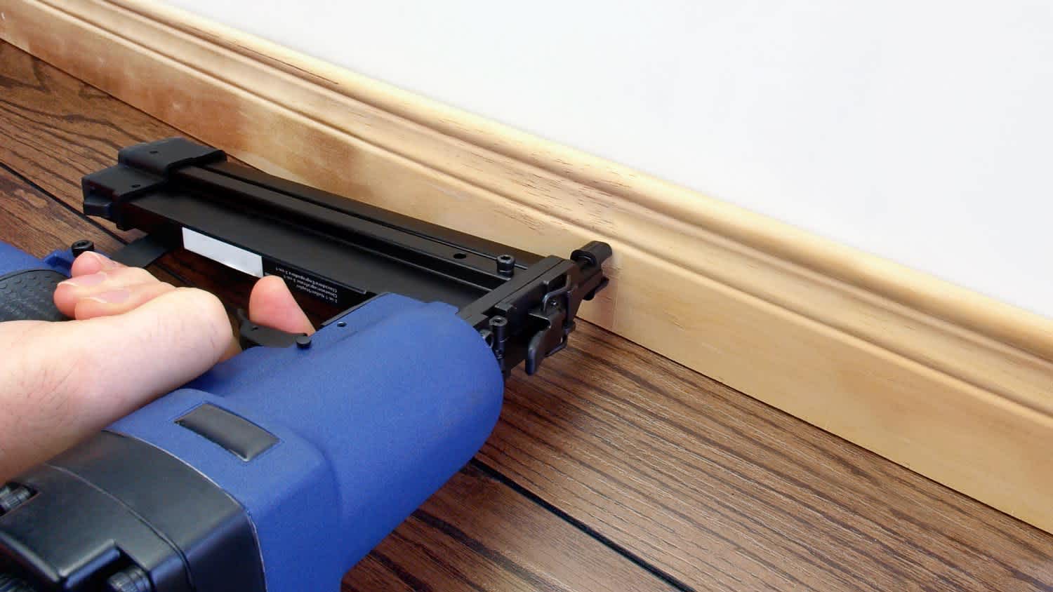 A man installing baseboard