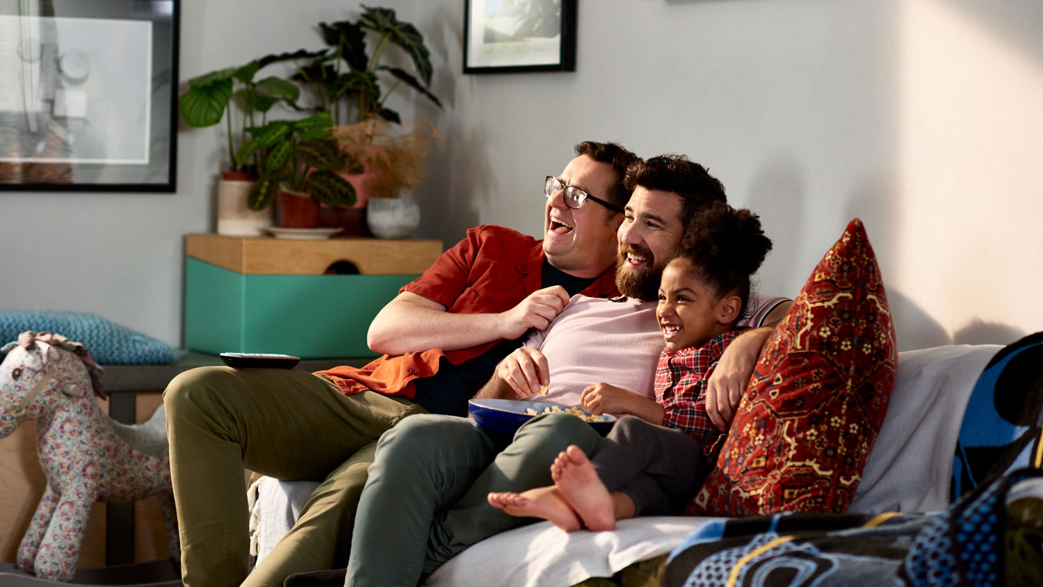 Fathers with their daughter watching tv and laughing