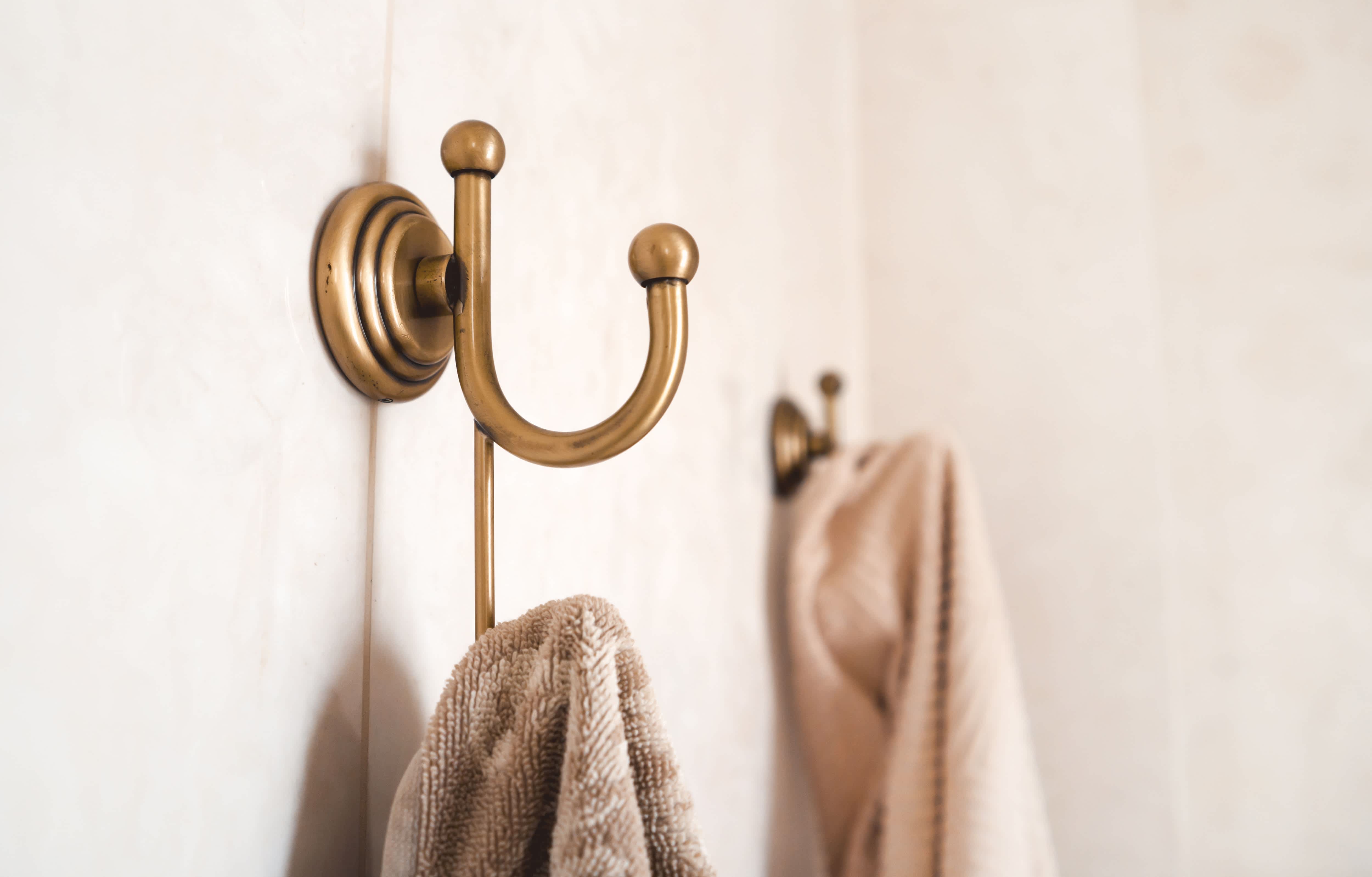 Modern bathroom with towels hanging from gold wall hooks