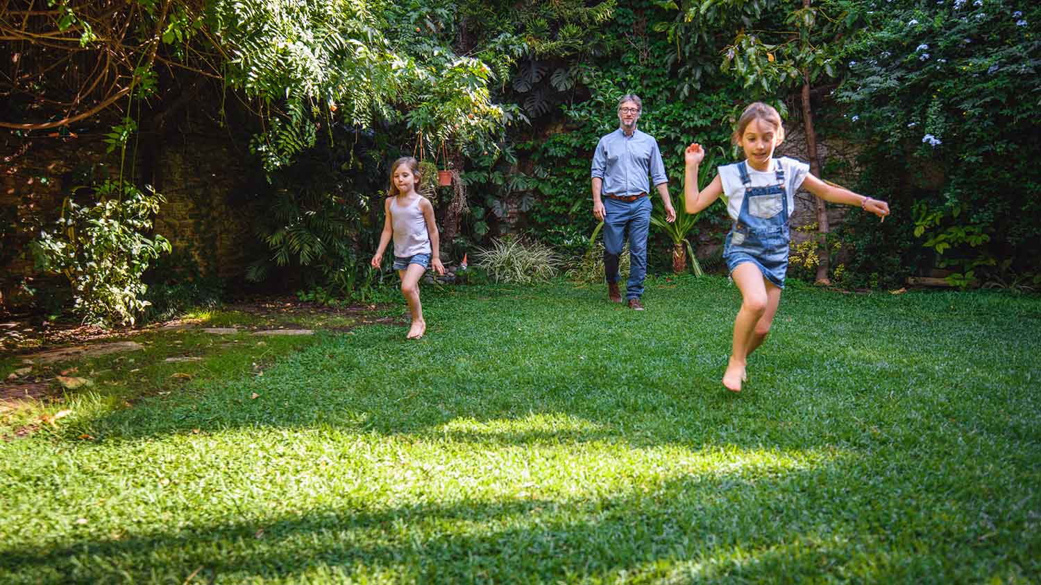 Father and daughters playing in the backyard