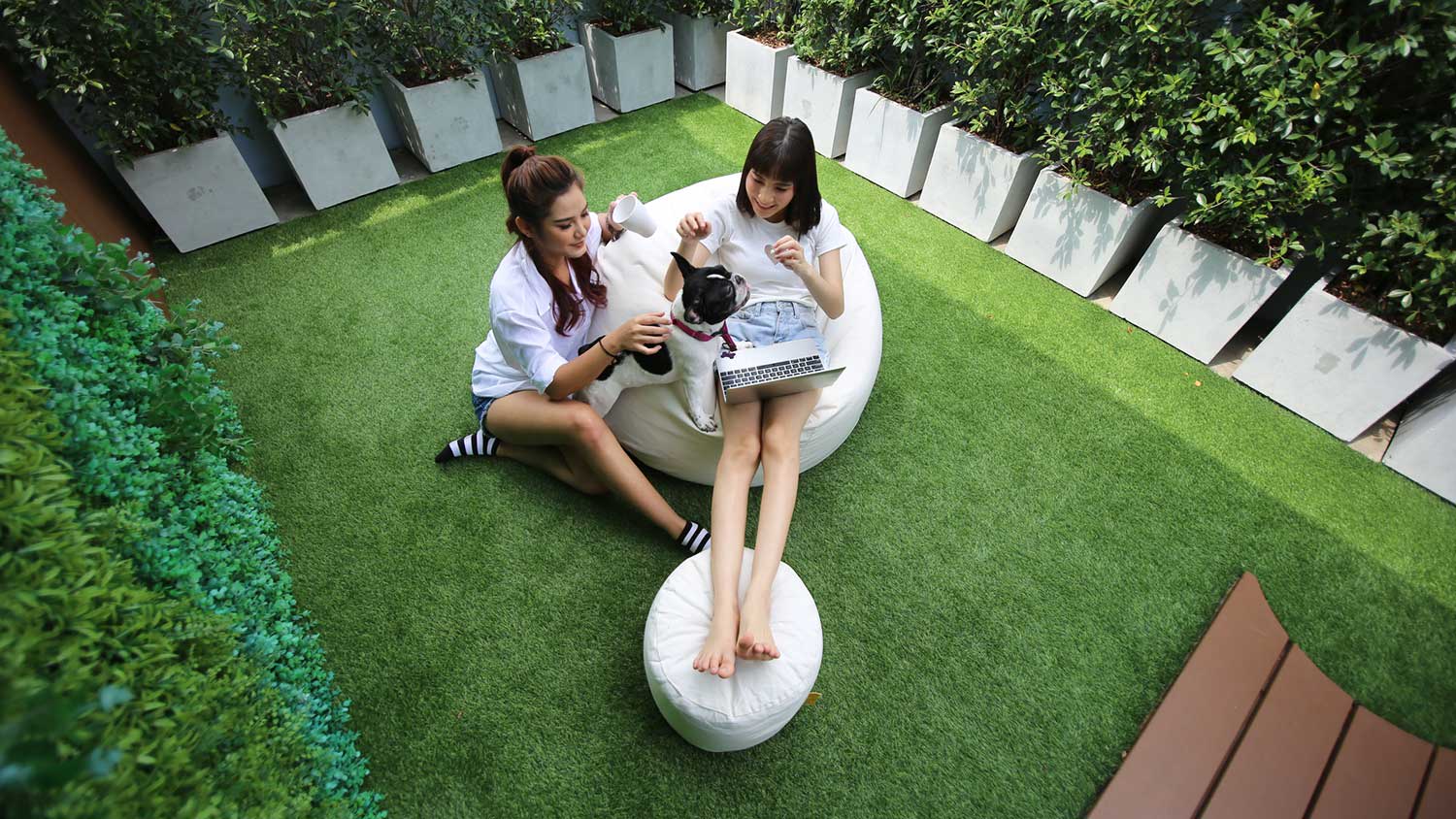 Friends sitting on a bean bag chair relaxing in the yard