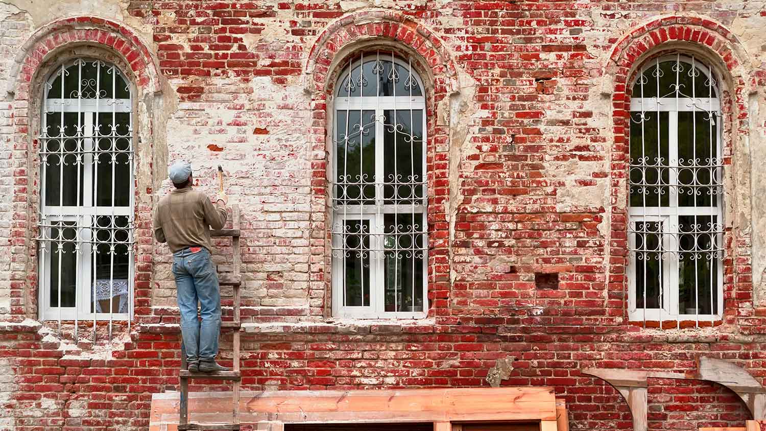 A man restores a brick wall