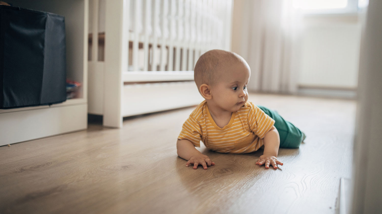 Baby boy crawling in his bedroom
