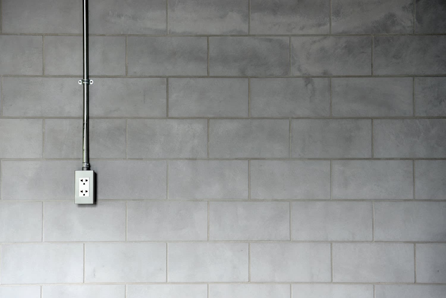 Steel pipe electric outlet on cement wall