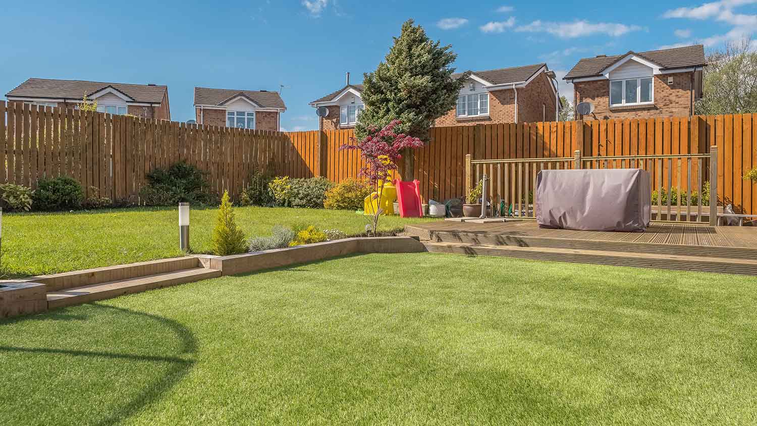 Large backyard with artificial turf and decking area