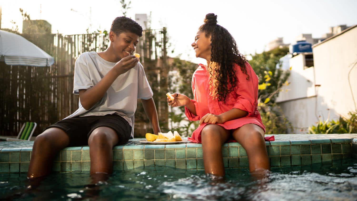 Friends eating fruit by the pool