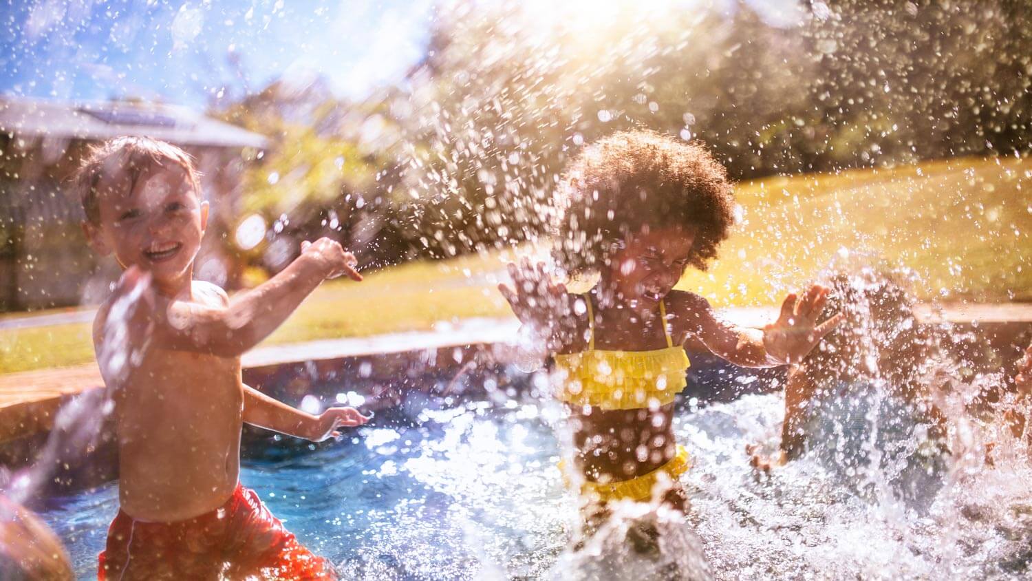 Friends playing in the pool in the backyard