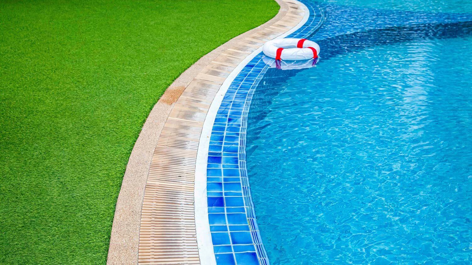A wide swimming pool with artificial turf