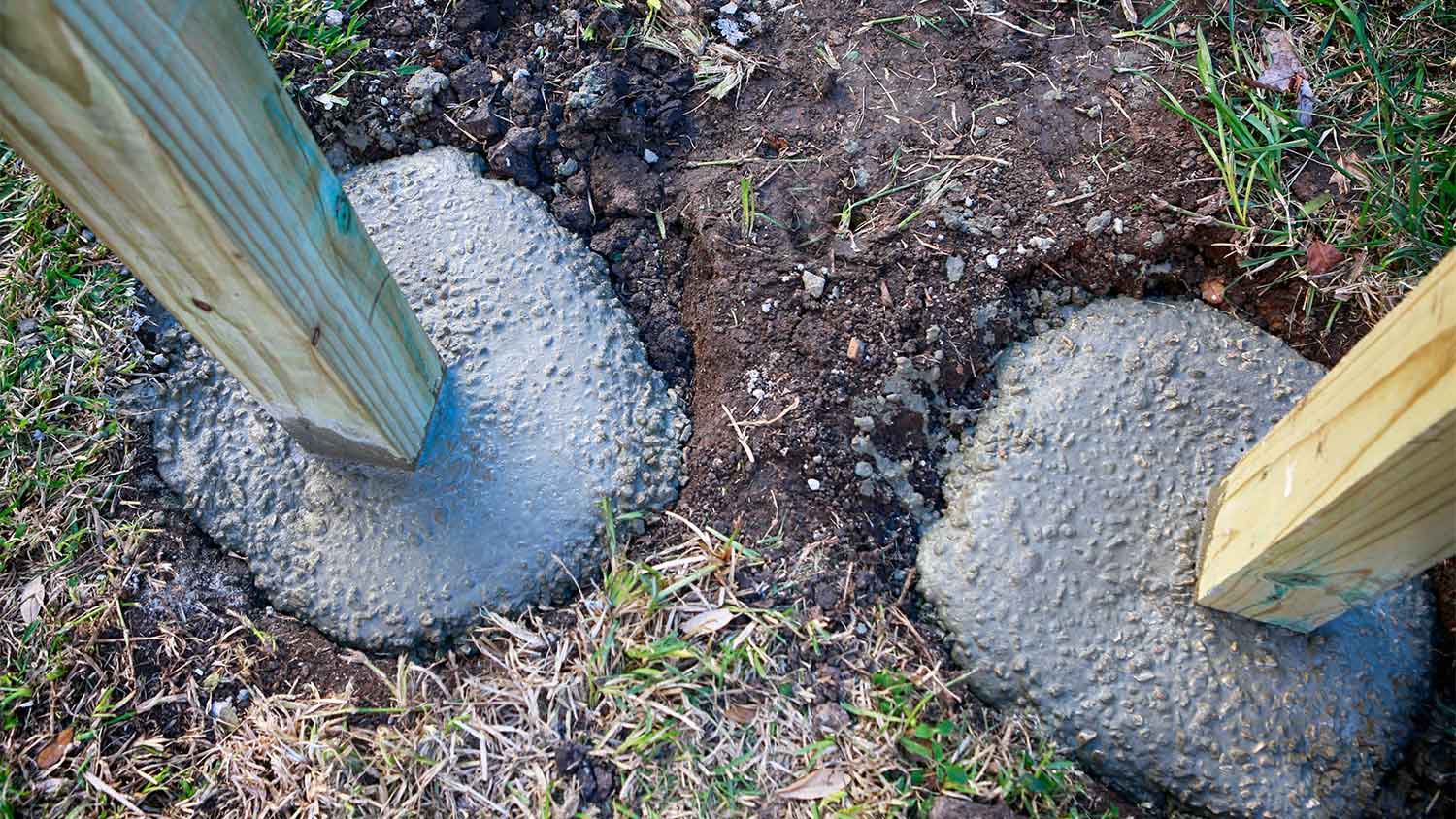 A fence post setting in concrete