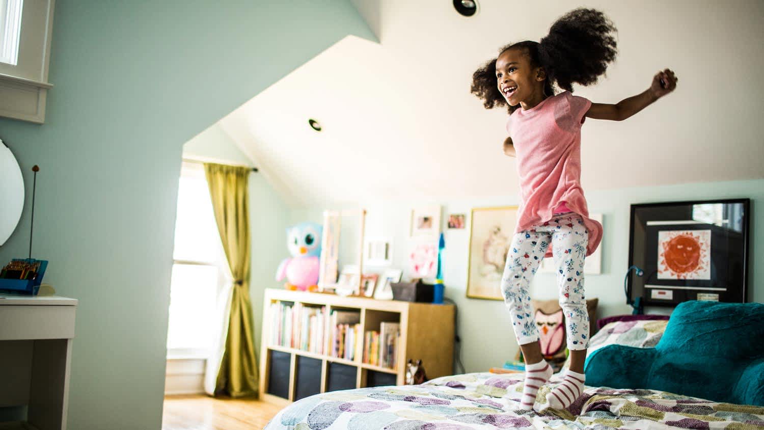 A girl jumping on her bed