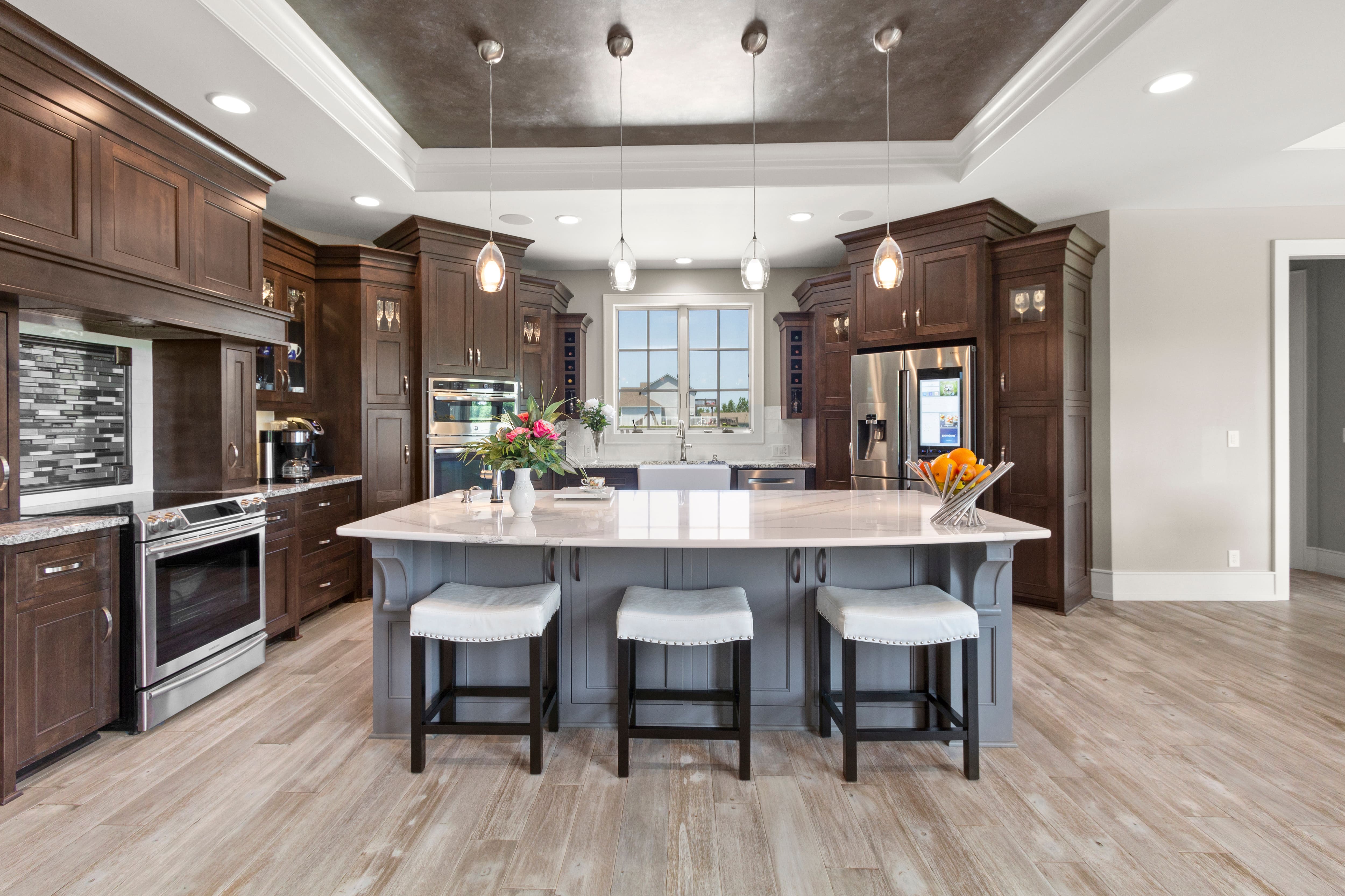 Gray kitchen island and dark wood surrounding cabinets