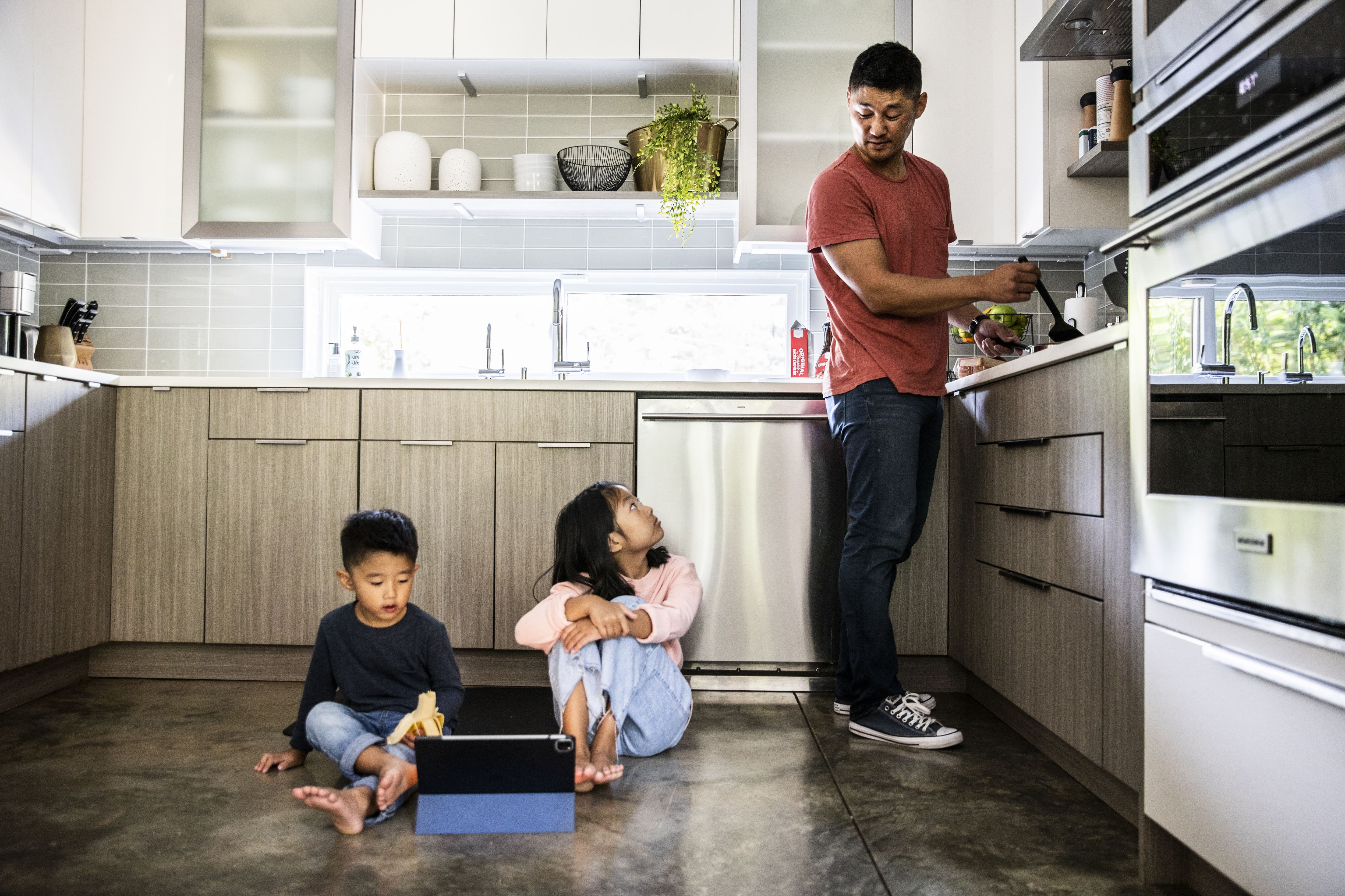 Father cooking for kids in modern kitchen