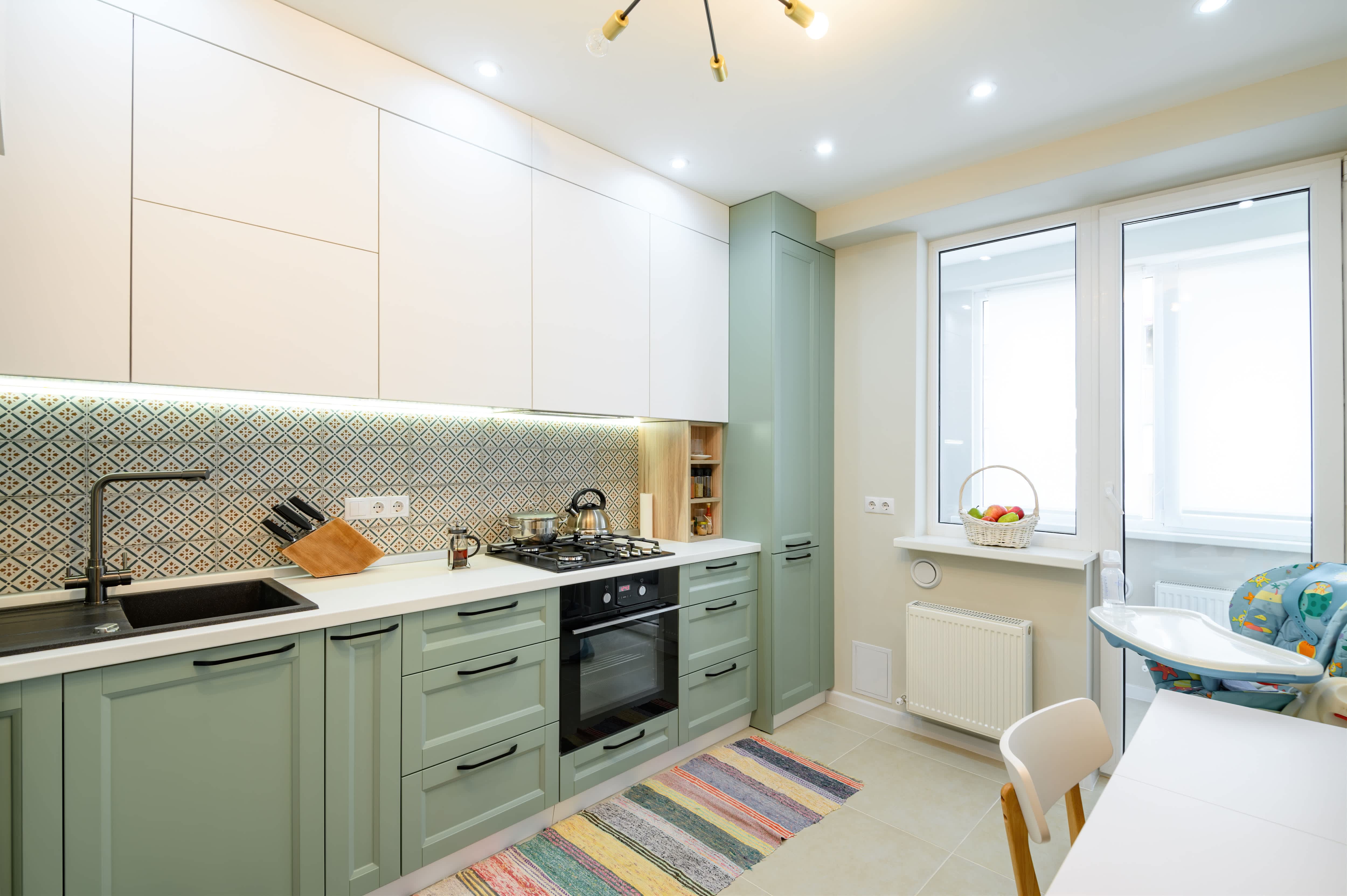 Sage green and white two-toned kitchen cabinets