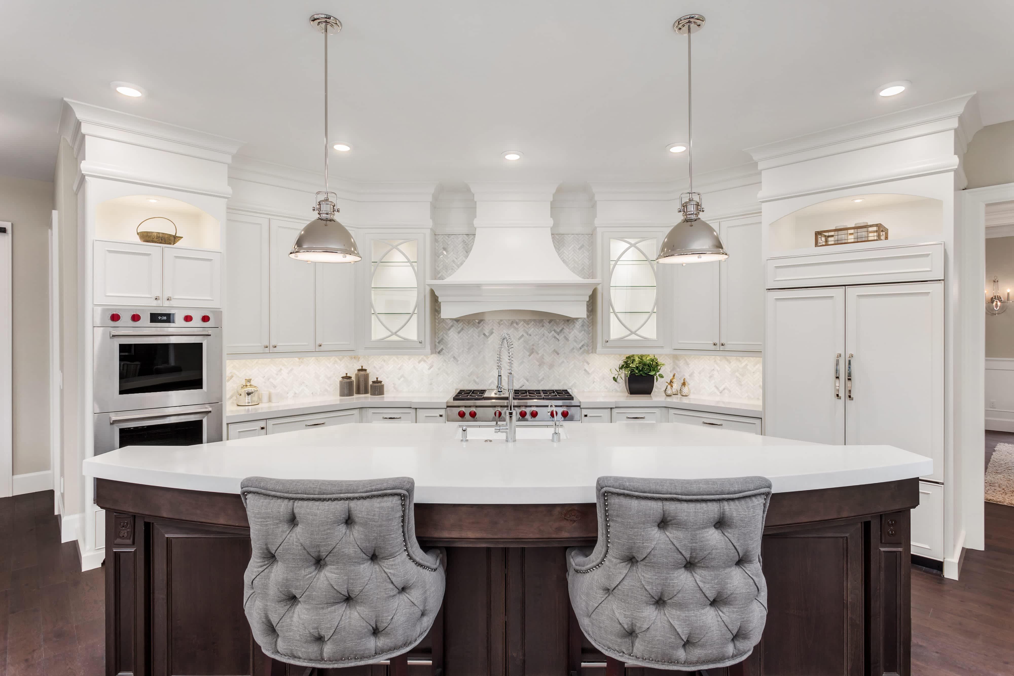 Luxury kitchen with white cabinets and dark wooden island