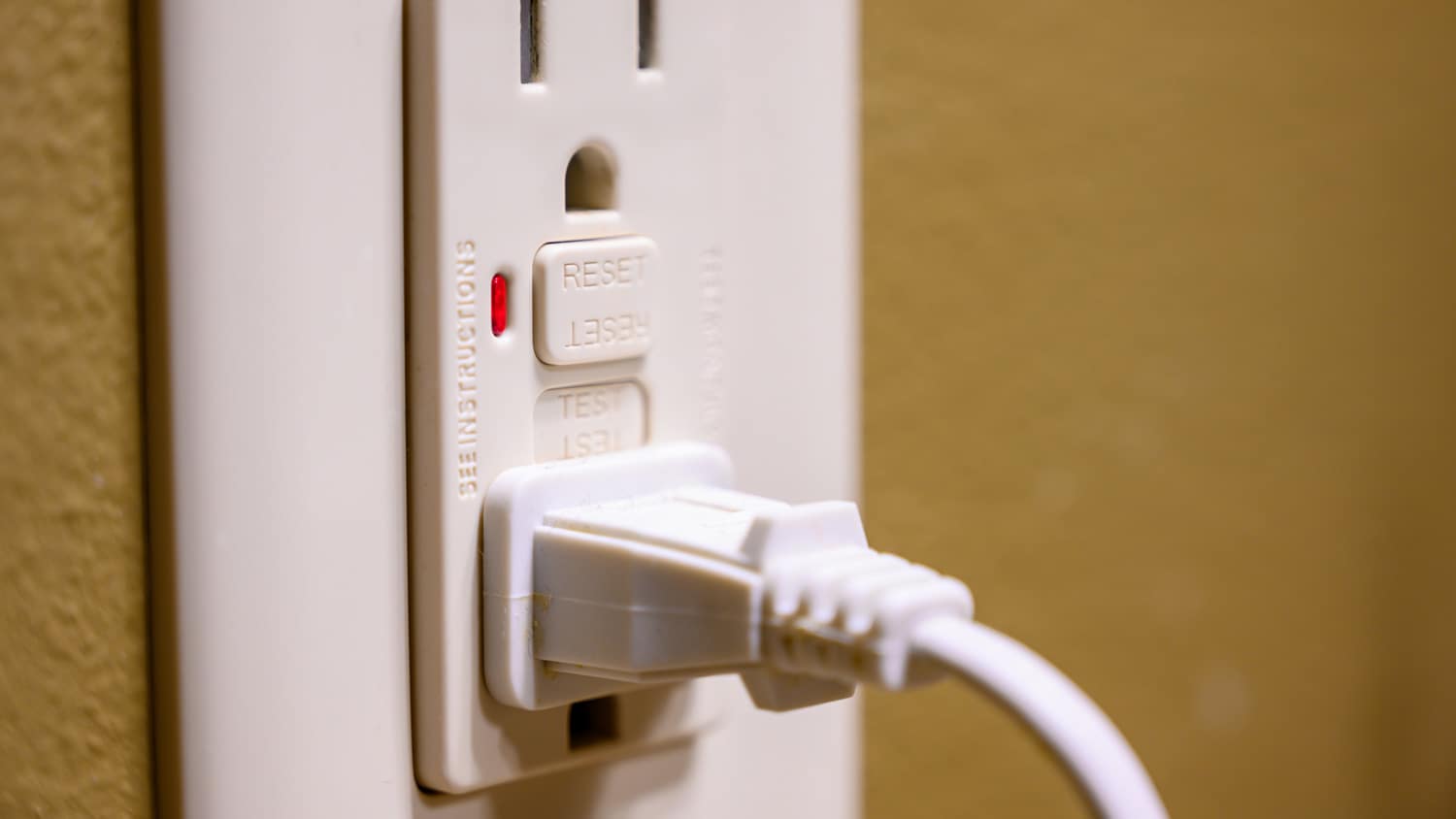 Person resetting GFCI outlet