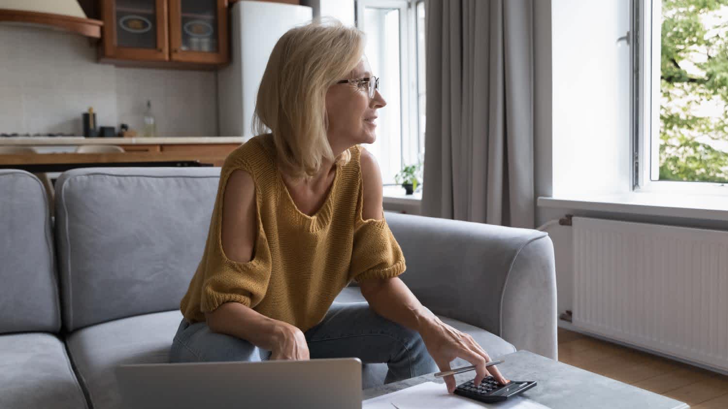 A woman thinking over monthly paperwork