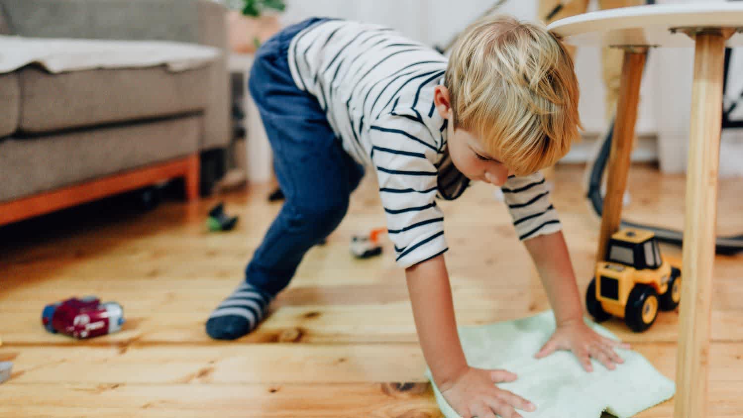 Young boy cleaning wood floors