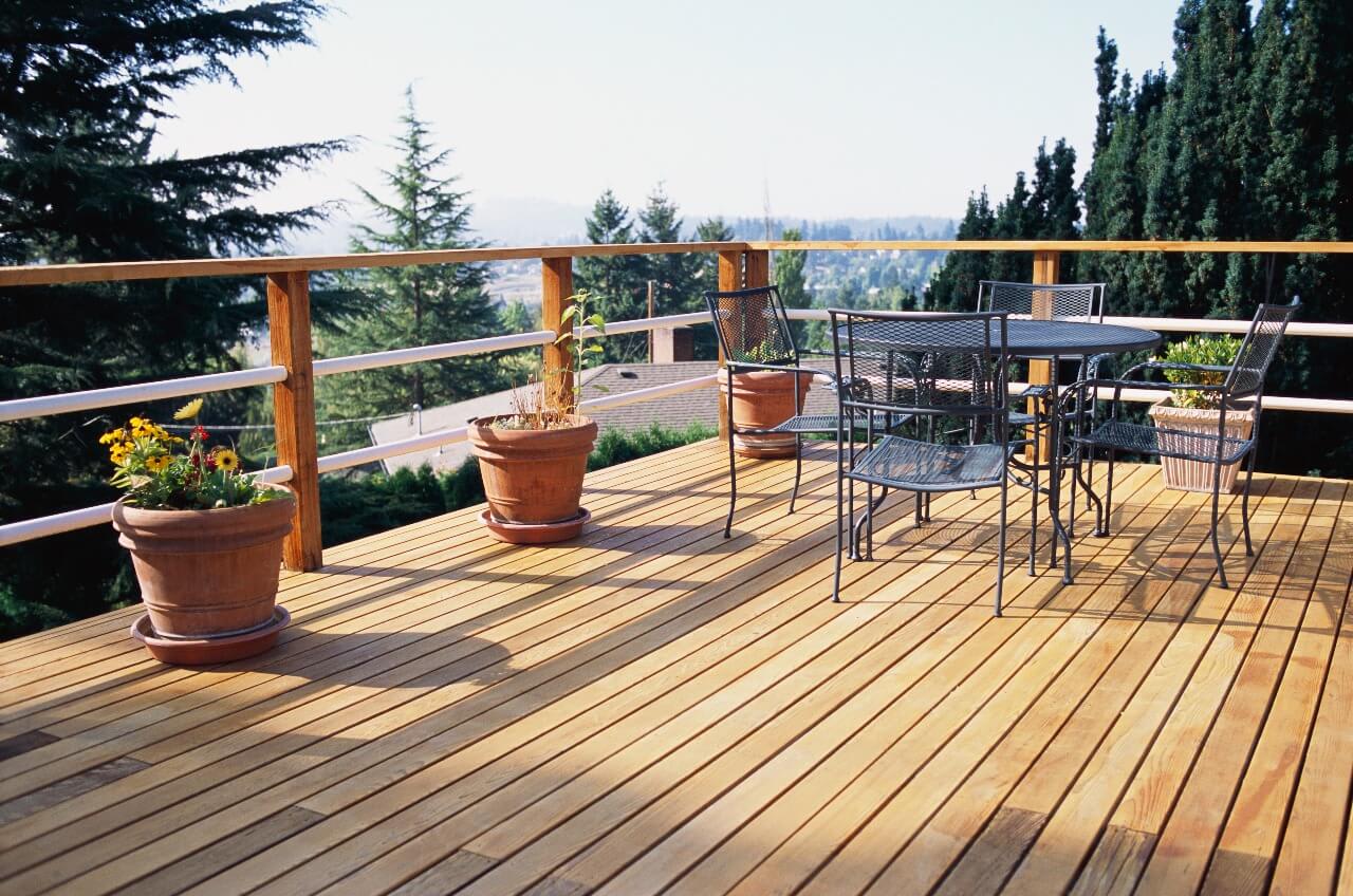 finished deck covered with five patio chairs and table overlooking grassy yard