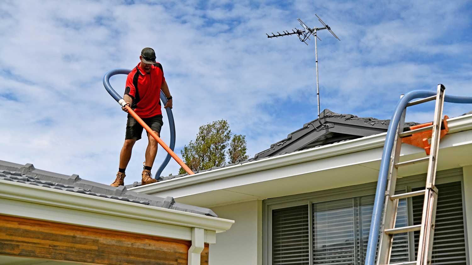 Worker using gutter vacuum cleaner