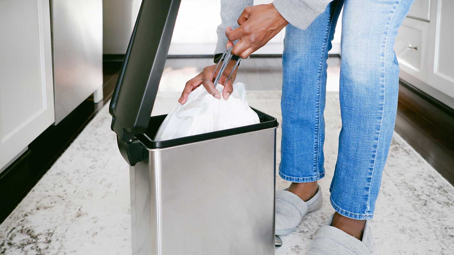 Closeup of a woman removing kitchen trash bag