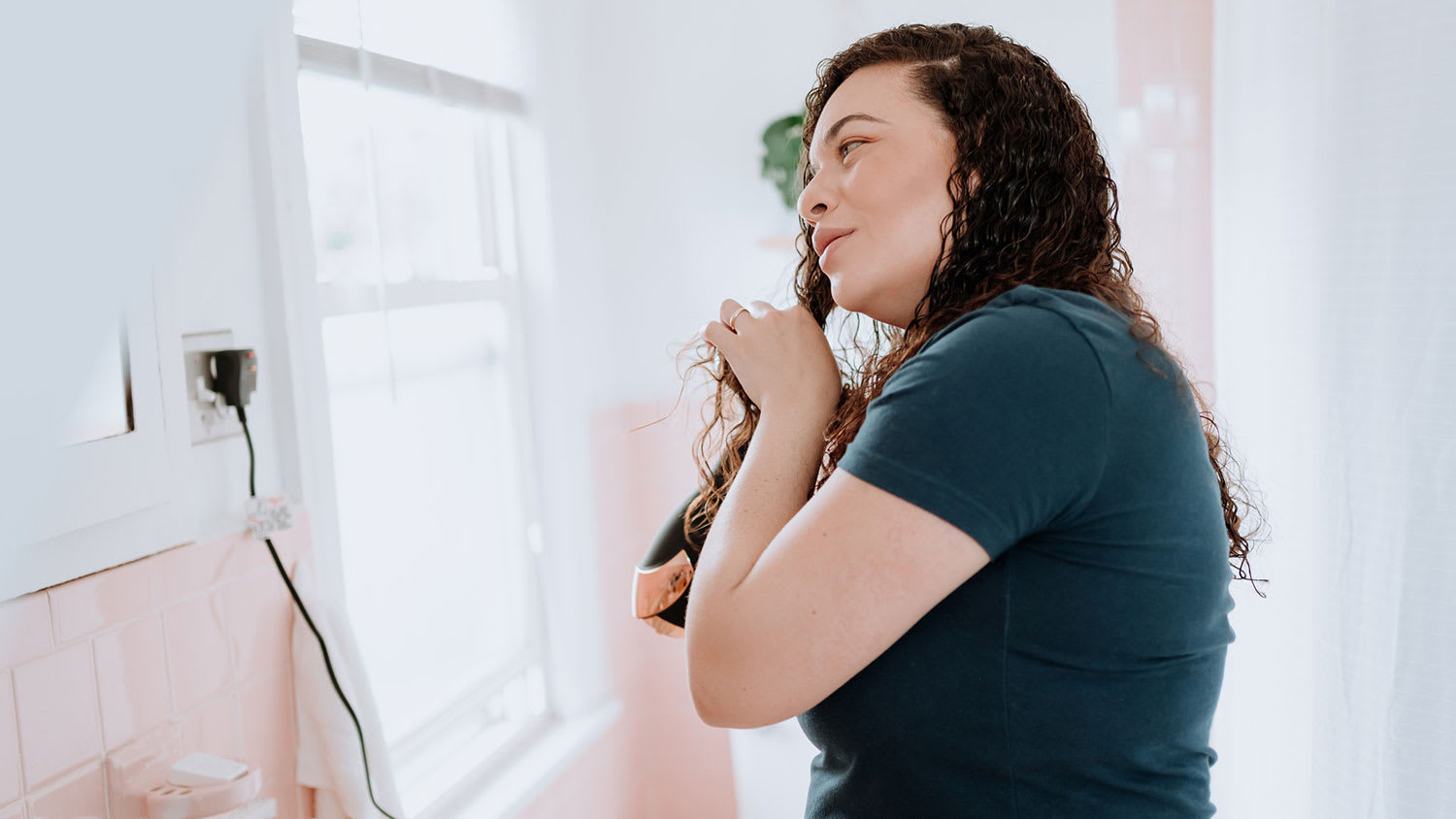 Woman using hair dryer to style her hair