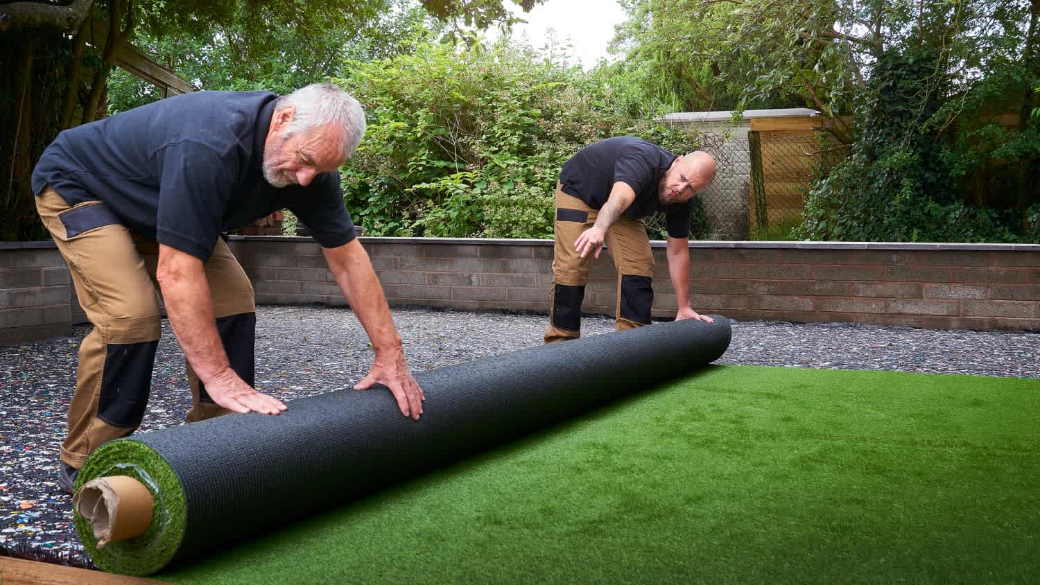 Men rolling out new artificial grass