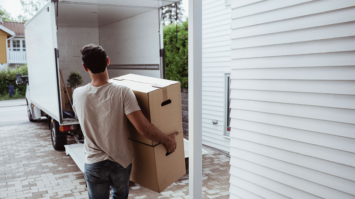 A man carrying boxes into a moving truck
