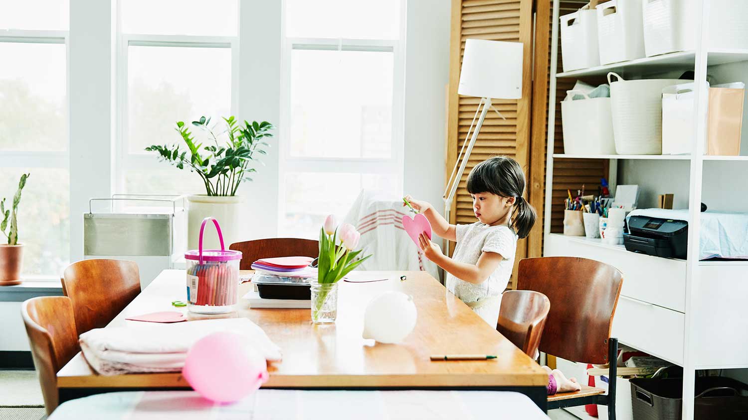 Girl in a craft room making heart shaped card