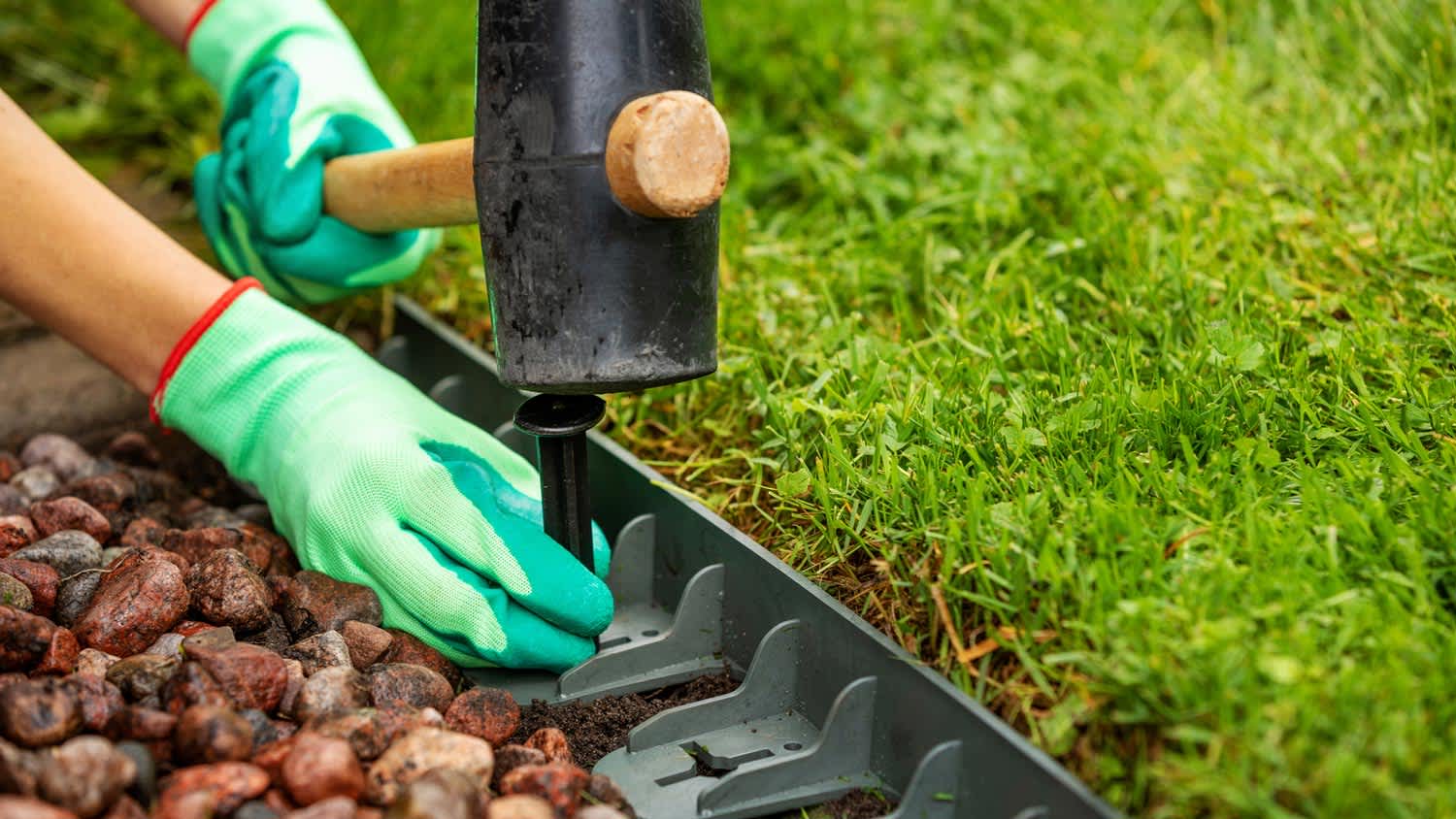 A man installing a plastic lawn edging