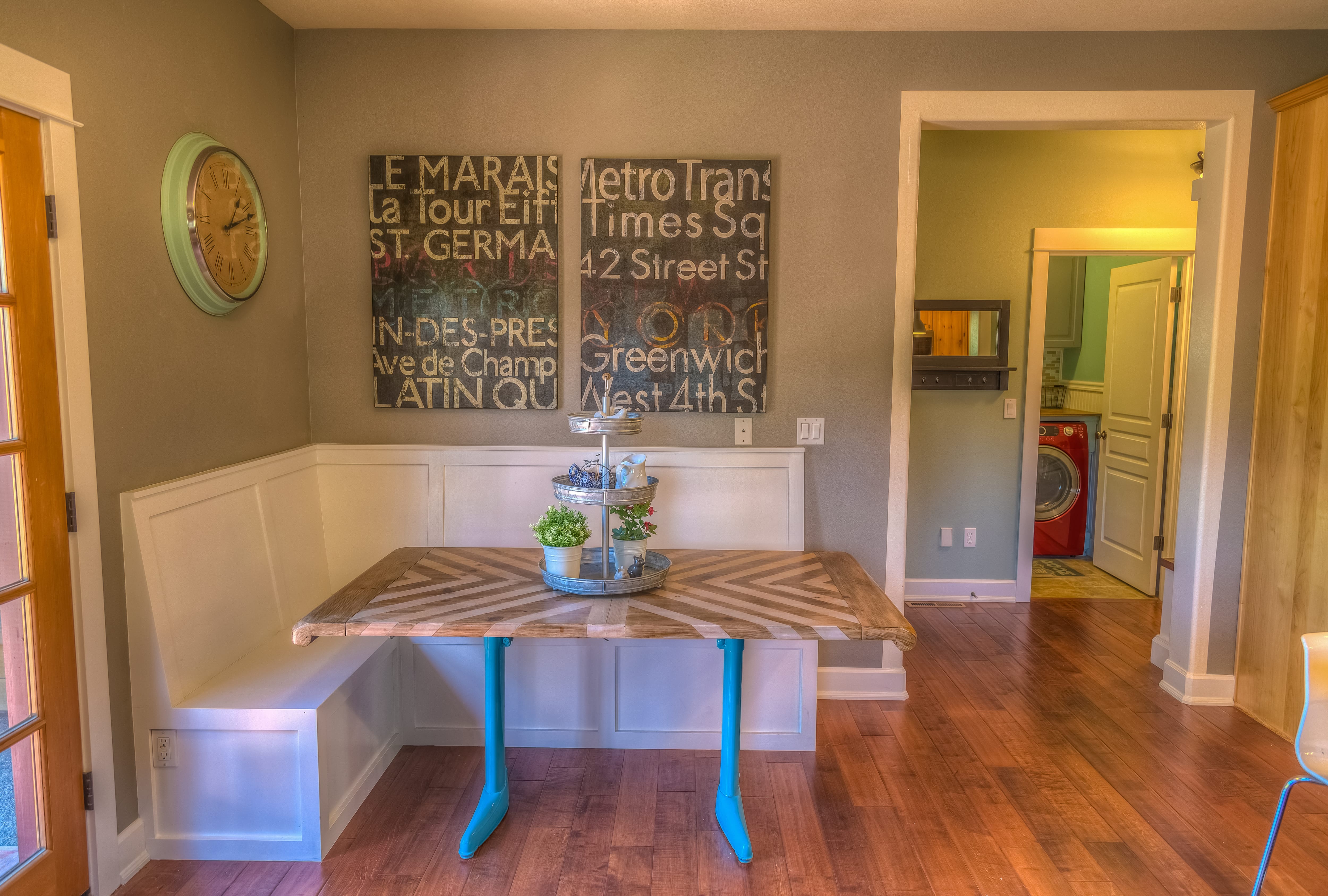 A kitchen nook with large word art hanging above a white bench