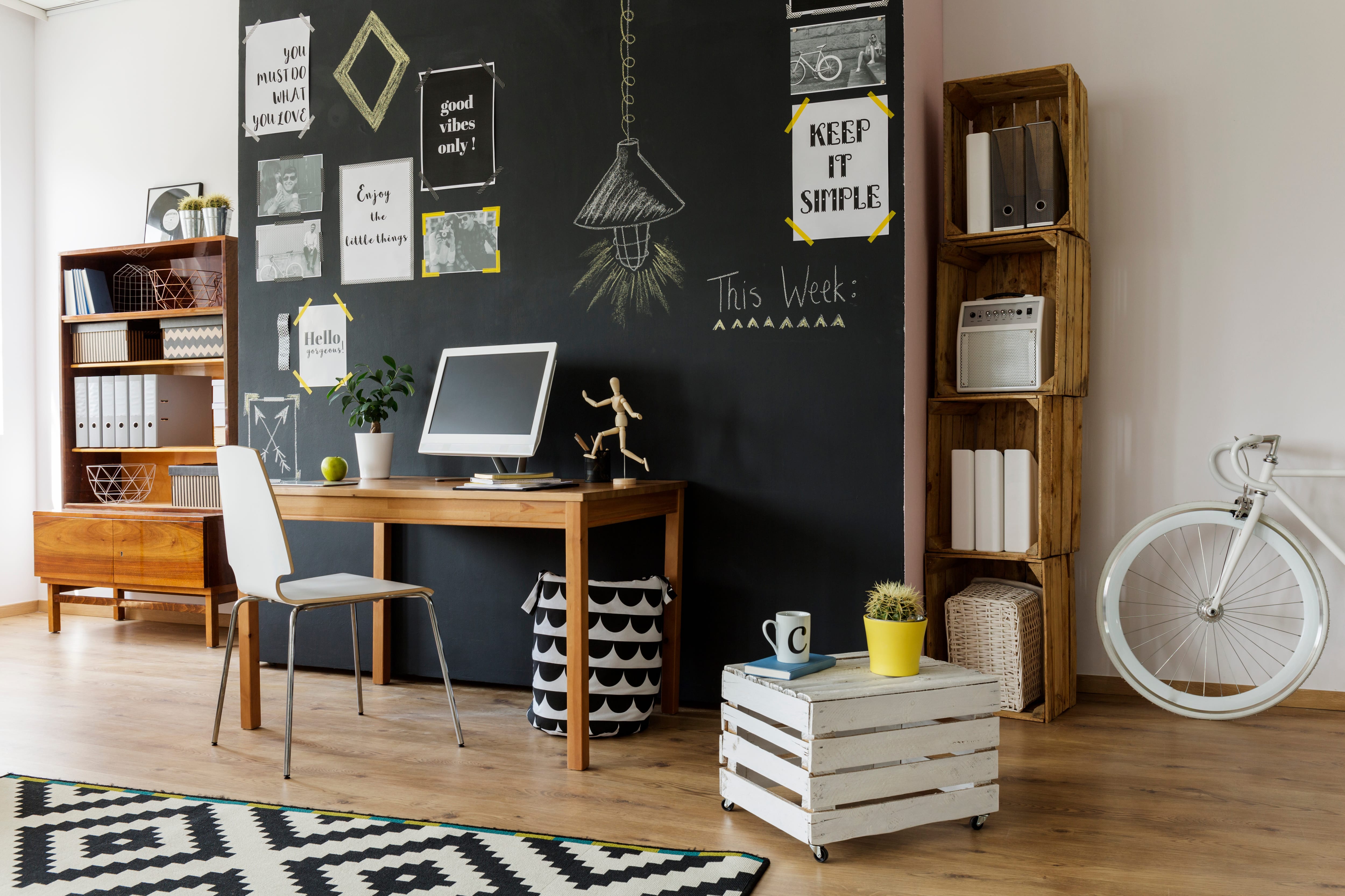 Home office with chalkboard wall, desk, computer monitor, and motivational quotes