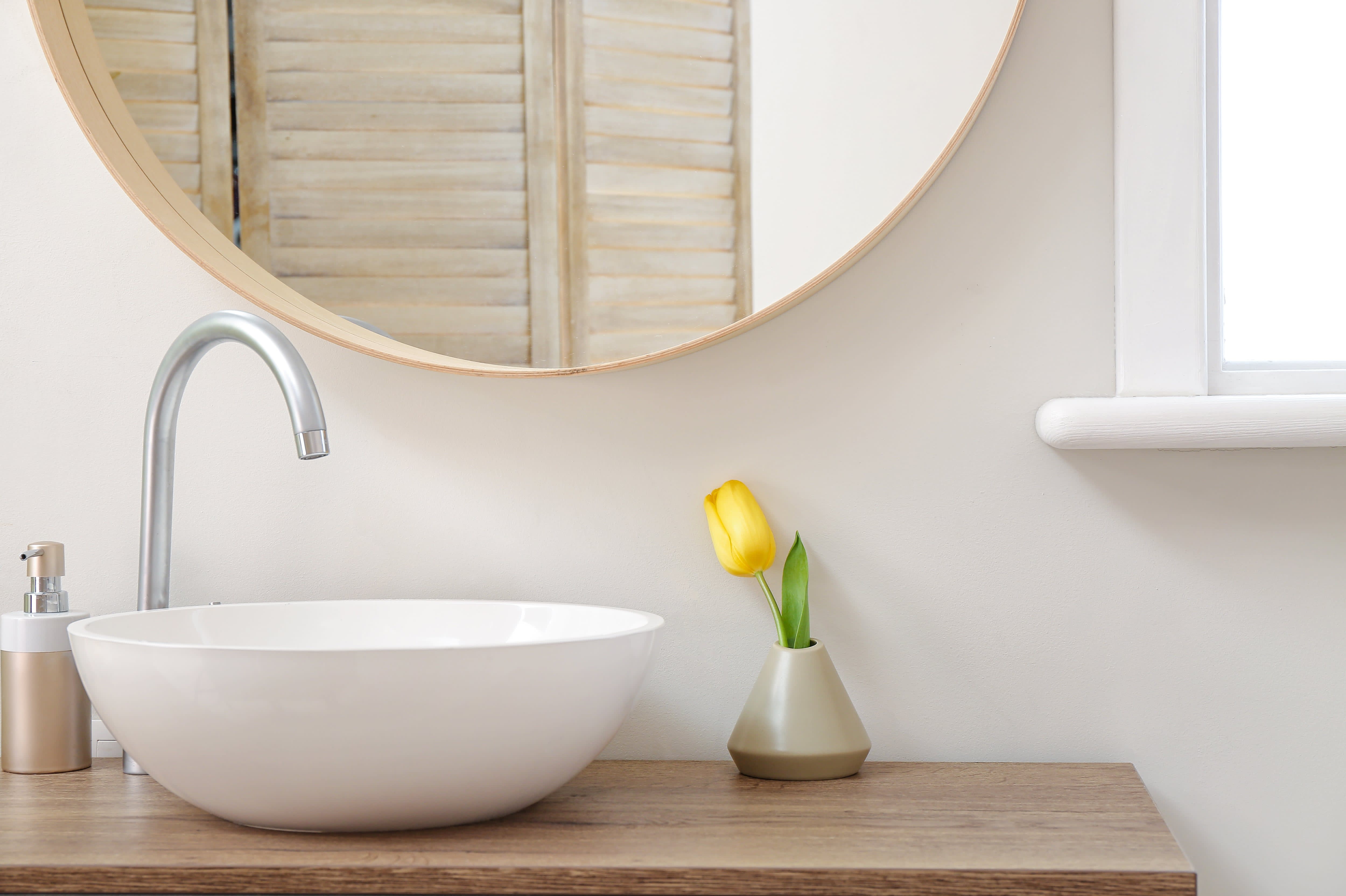 Wood frame mirror hung in bathroom