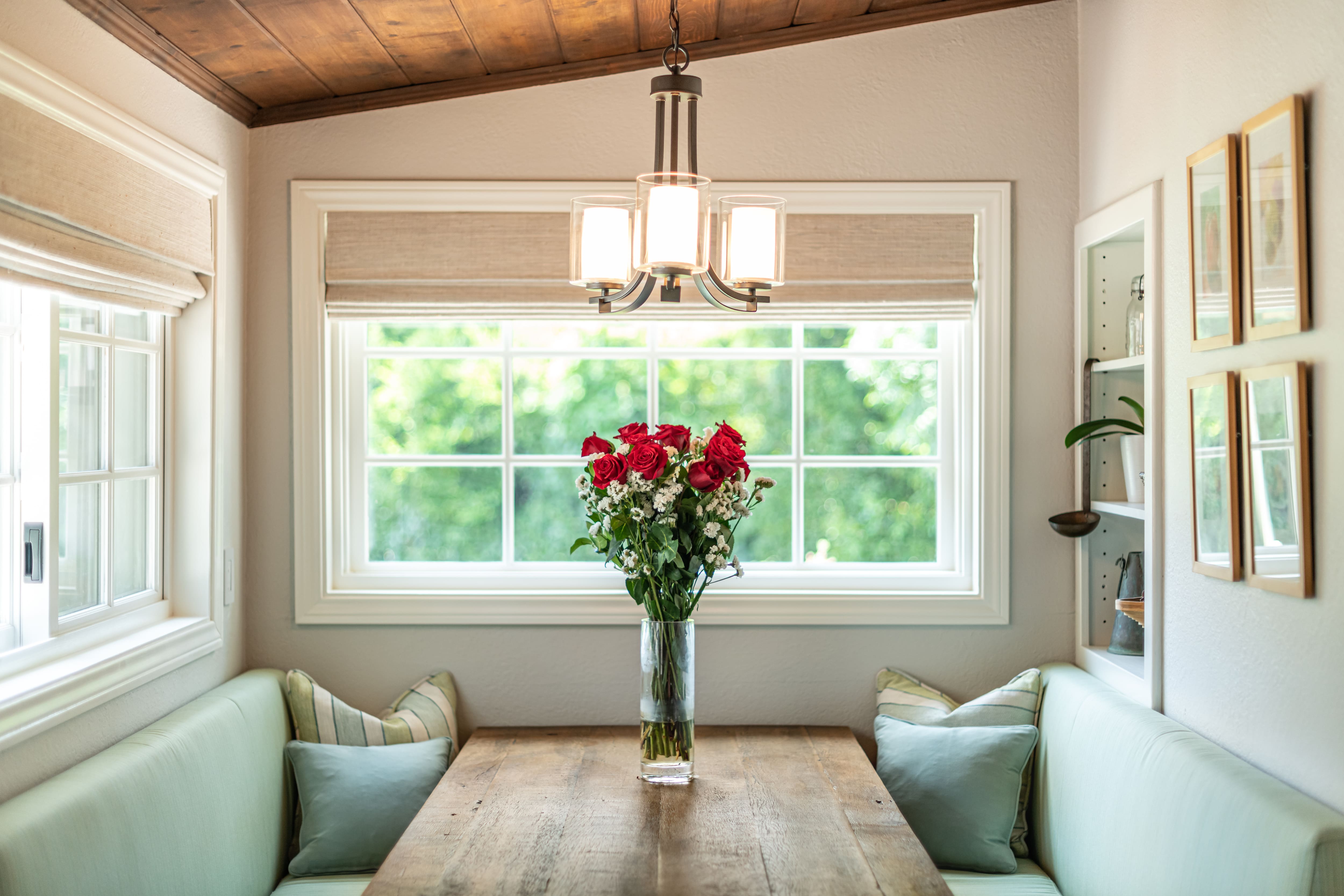 A rustic kitchen nook with upholstered benches and throw pillows