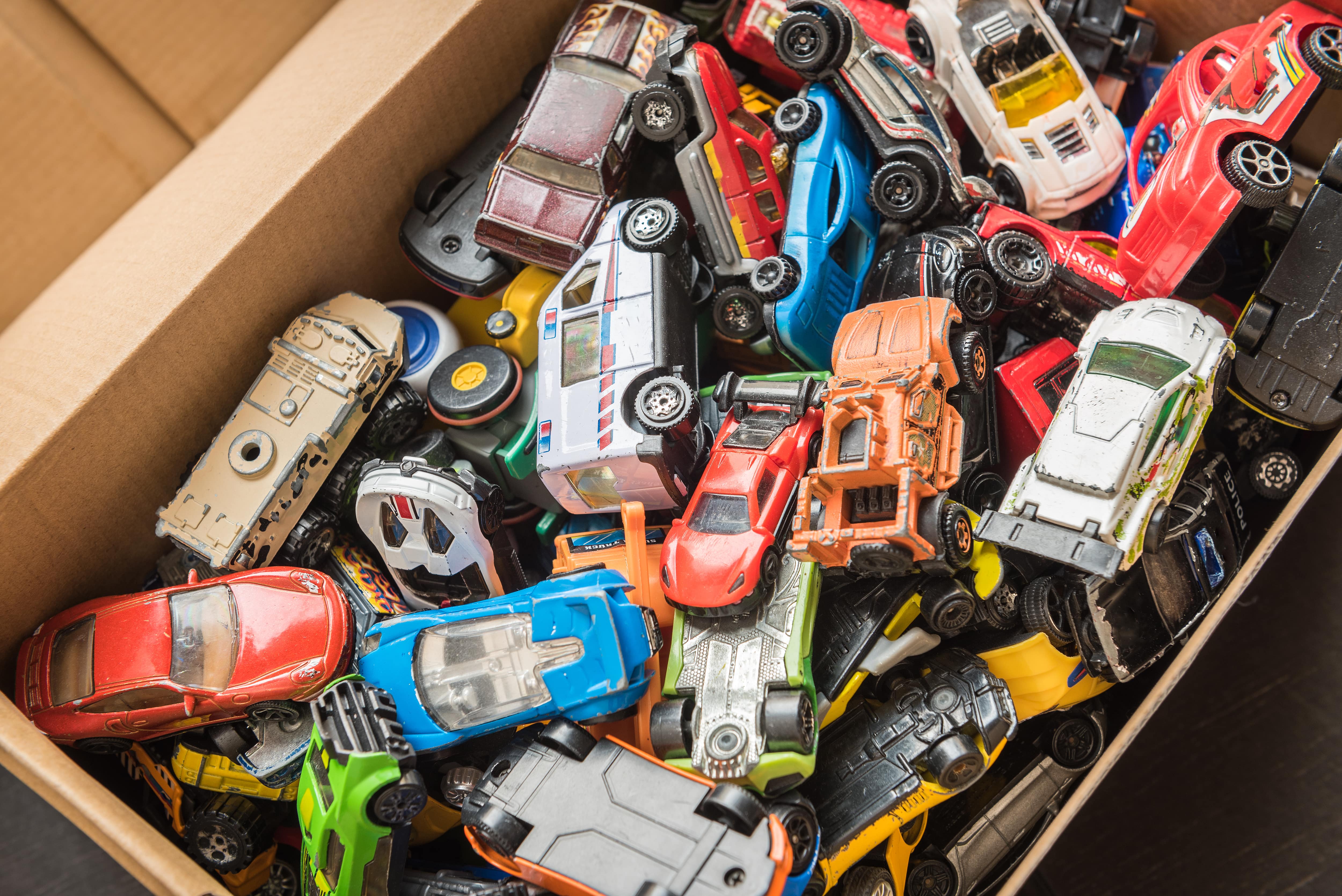 A cardboard box full of toy cars