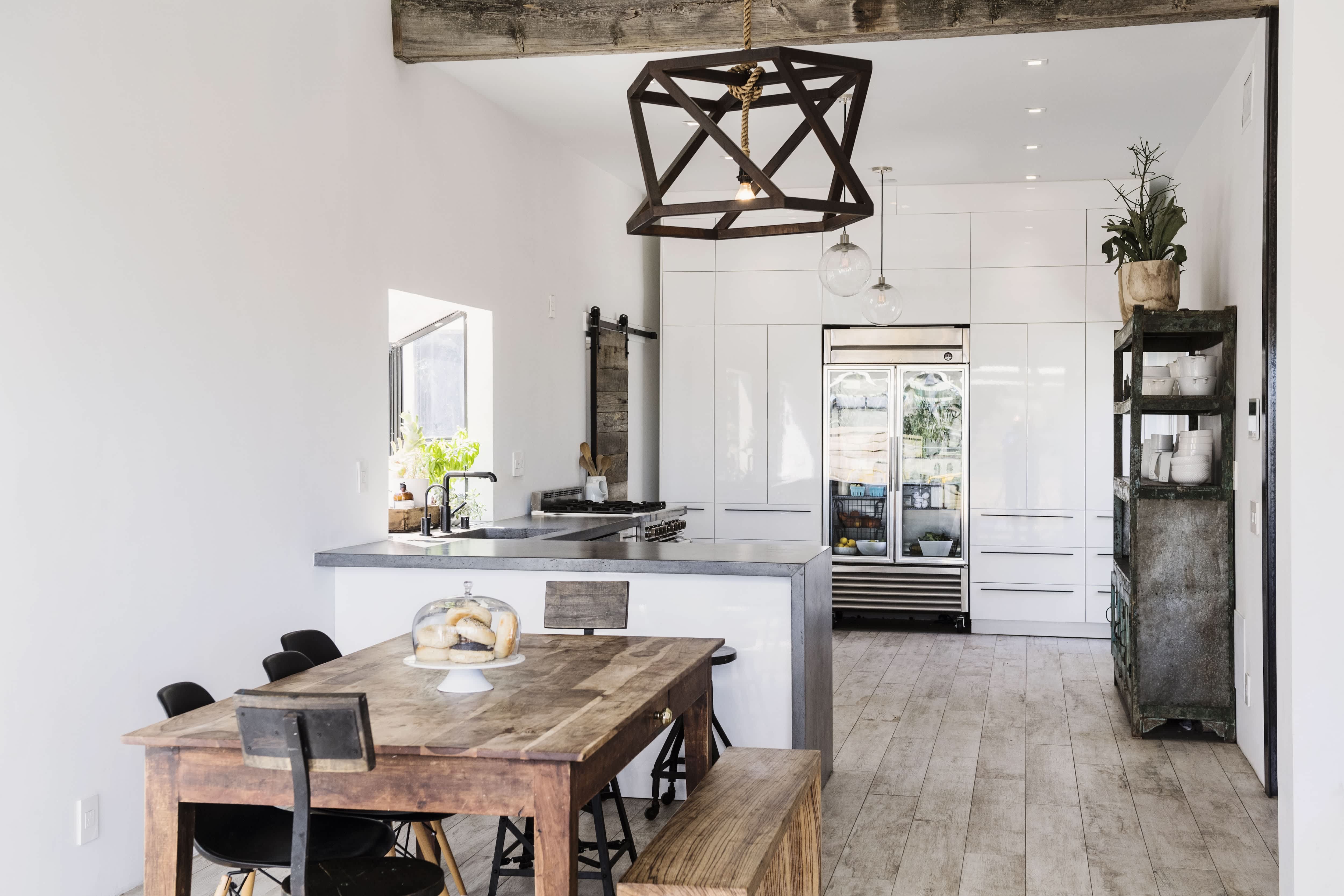 An open farmhouse style kitchen with a long wood table and bench seating