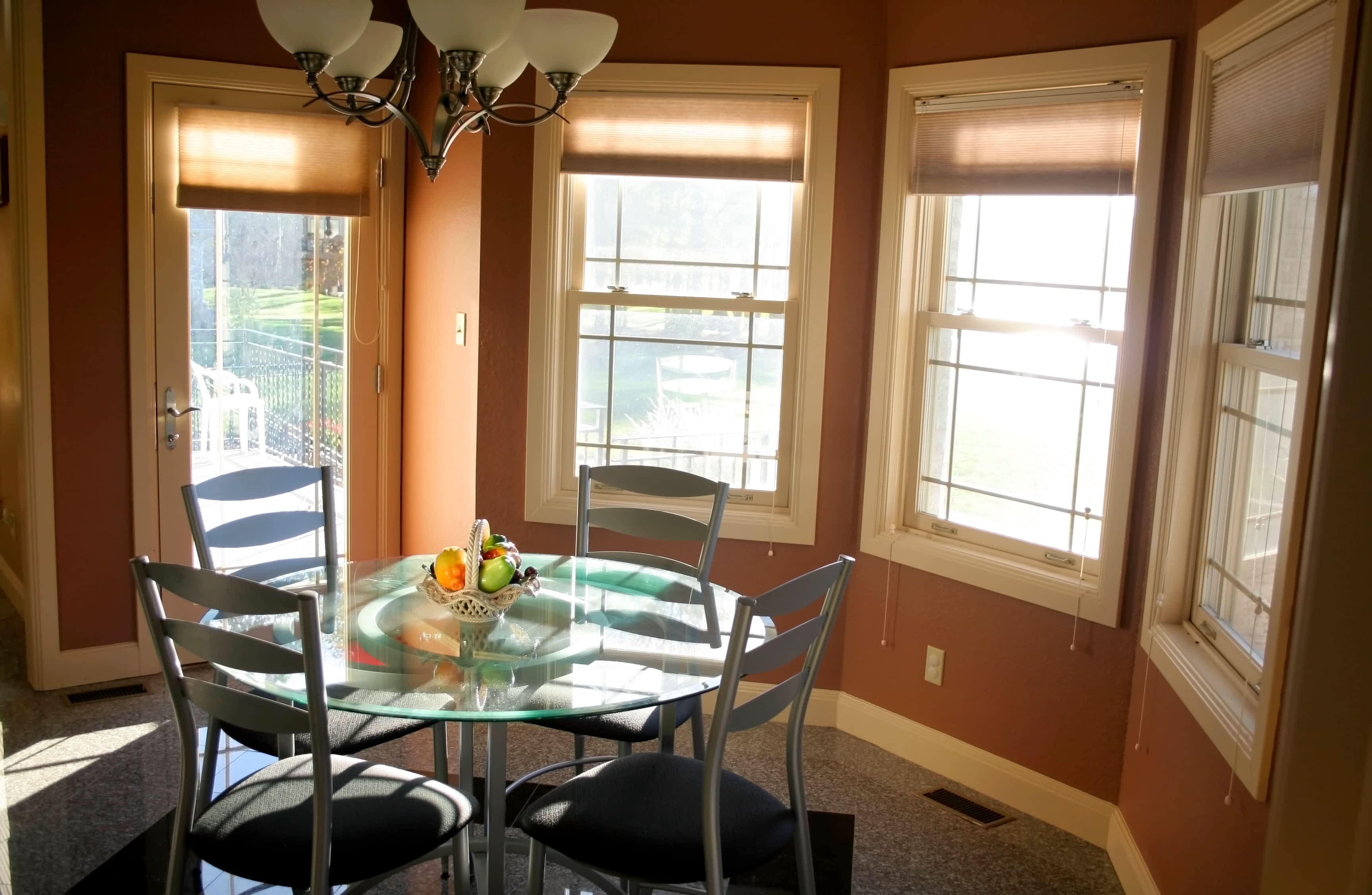 A round glass table in a bay window nook