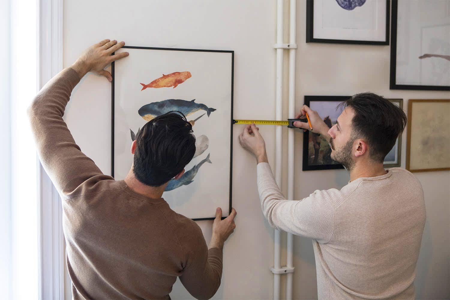 couple decorating walls with artwork