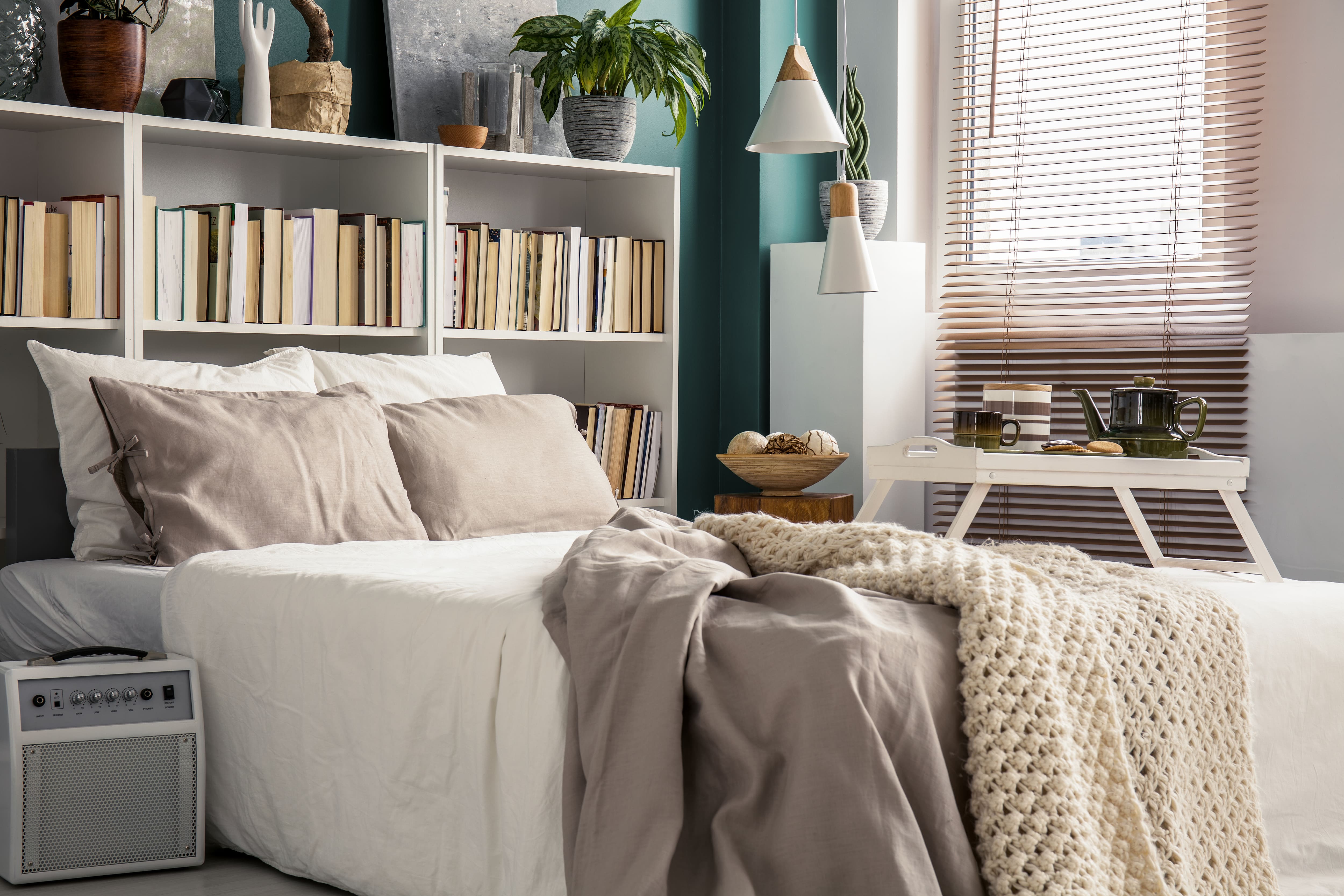 A small bedroom with a bookshelf headboard