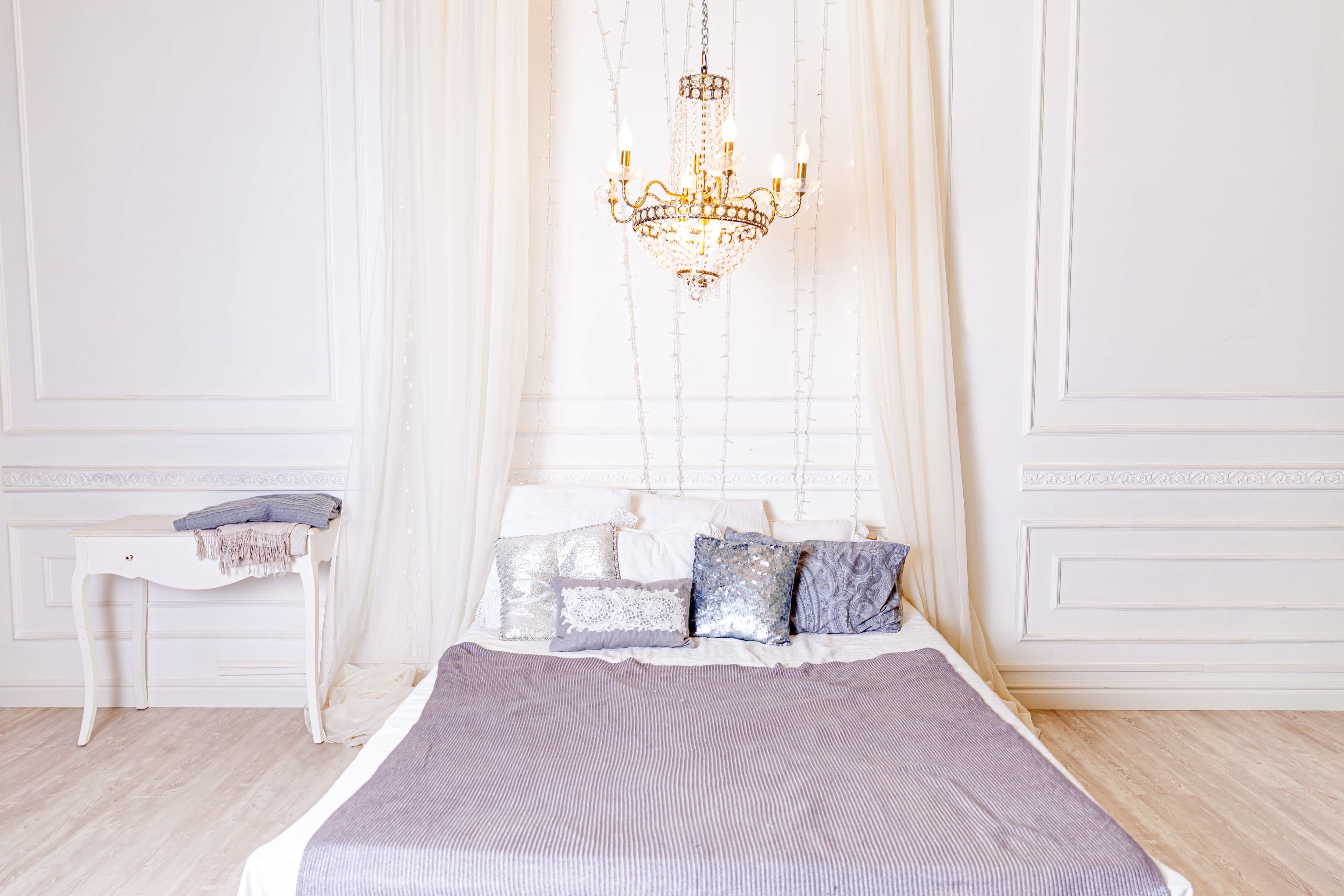 A bed with a curtain headboard in a white and purple room