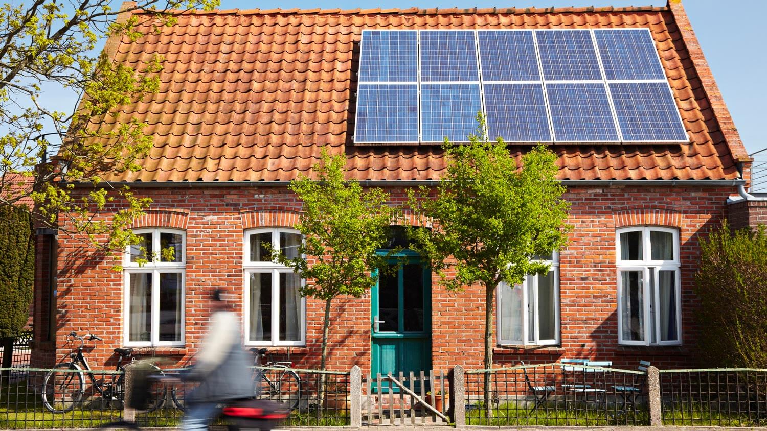 A brick house with solar power technology installed on the roof