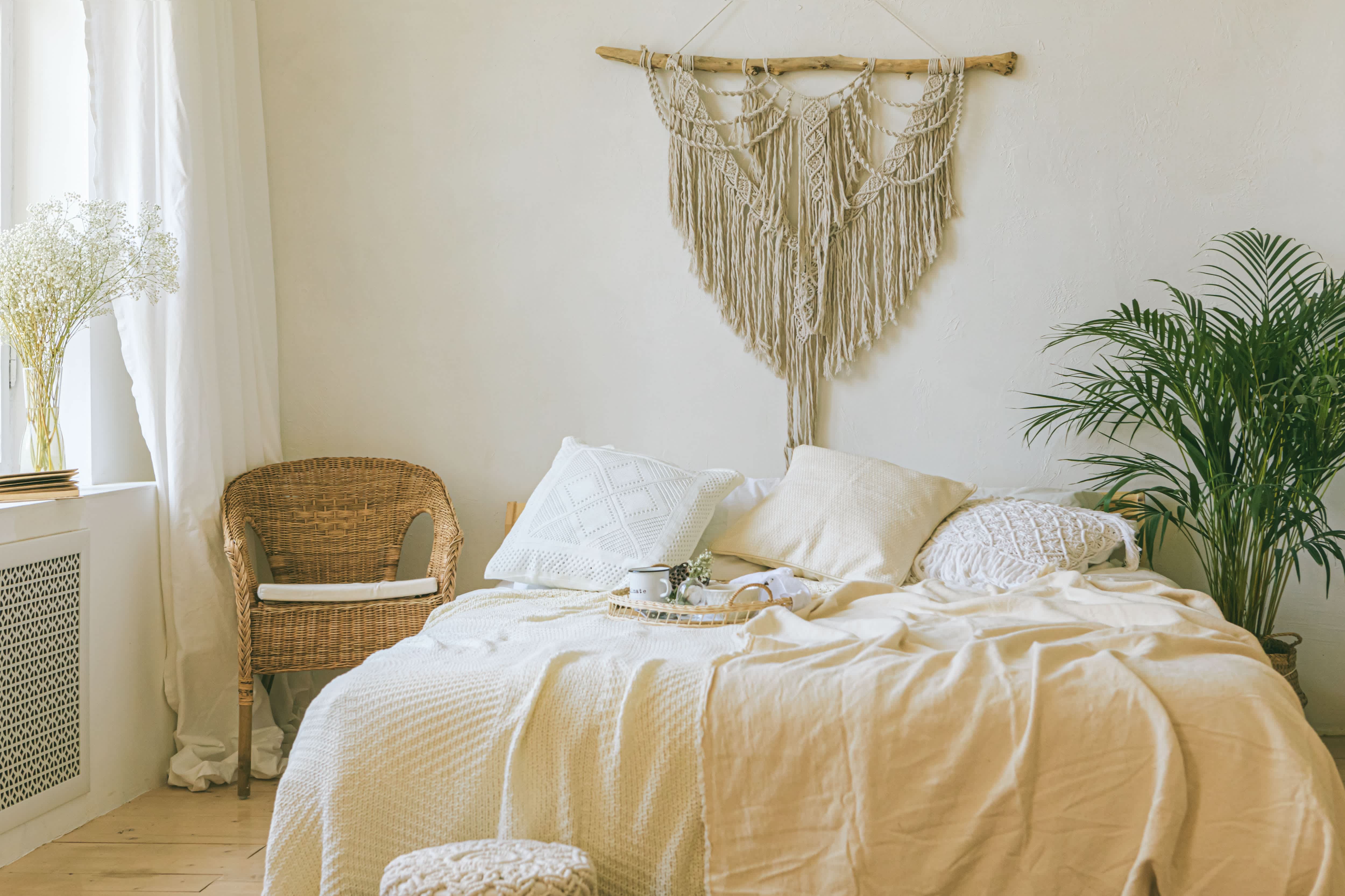 A neutral bedroom with a macrame headboard