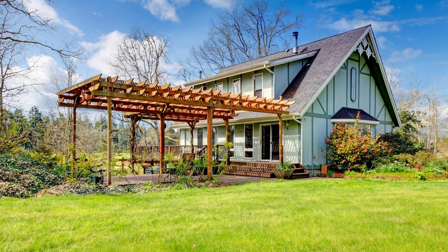 A beautiful farmhouse with an attached to the deck pergola