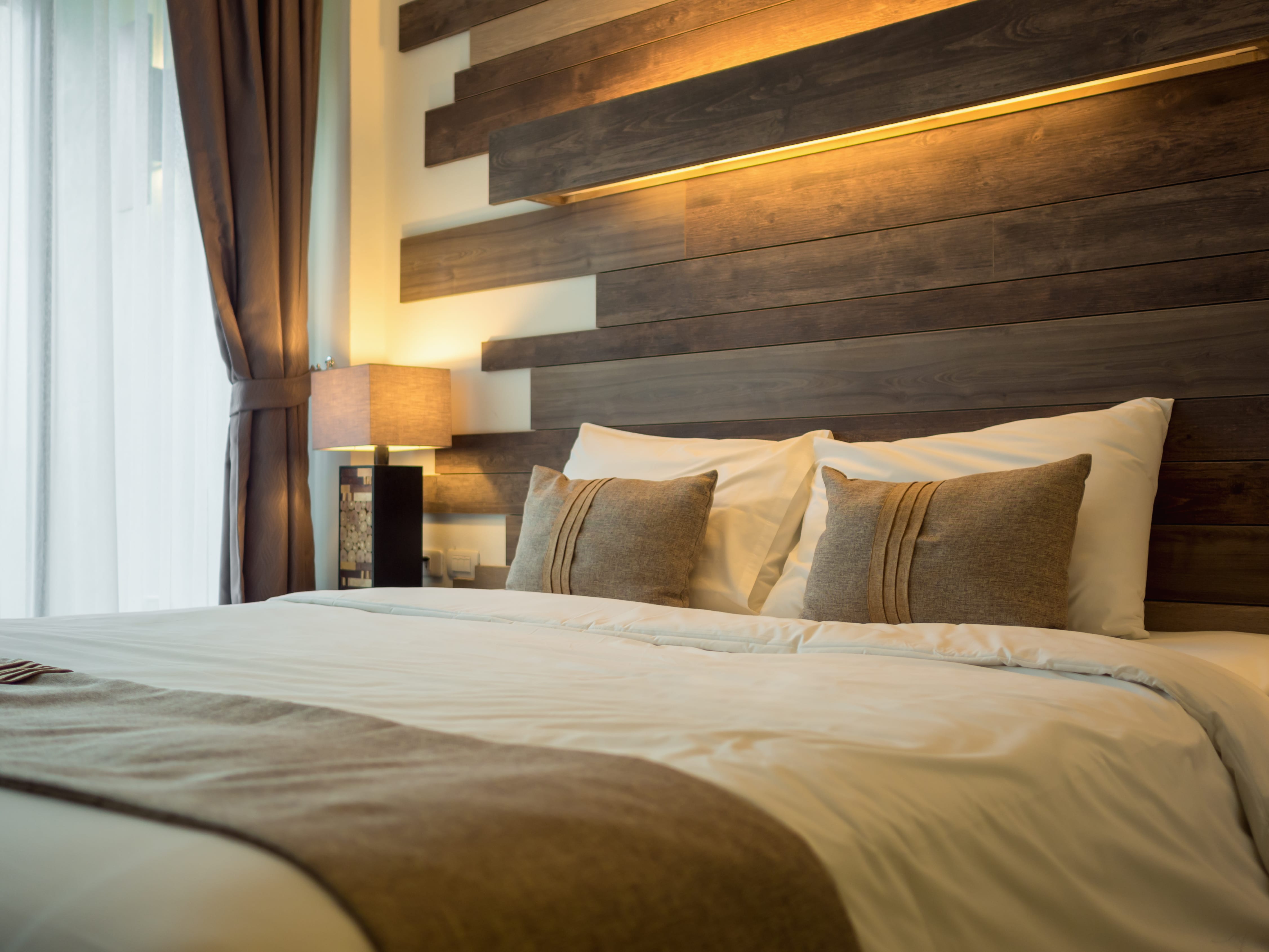 A cozy bedroom with a large bed in front of a wood accent wall