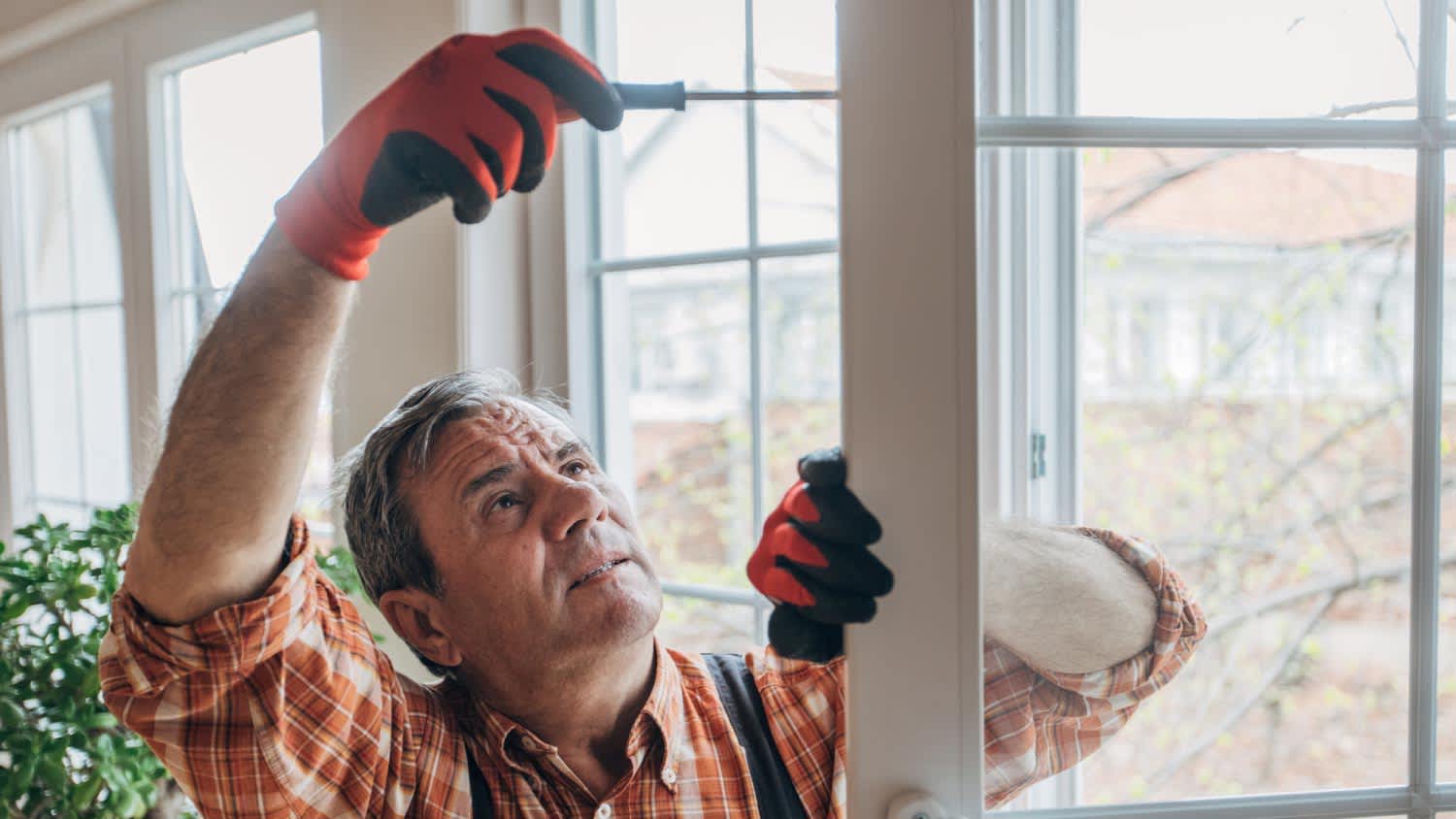 Man installing new window in living room