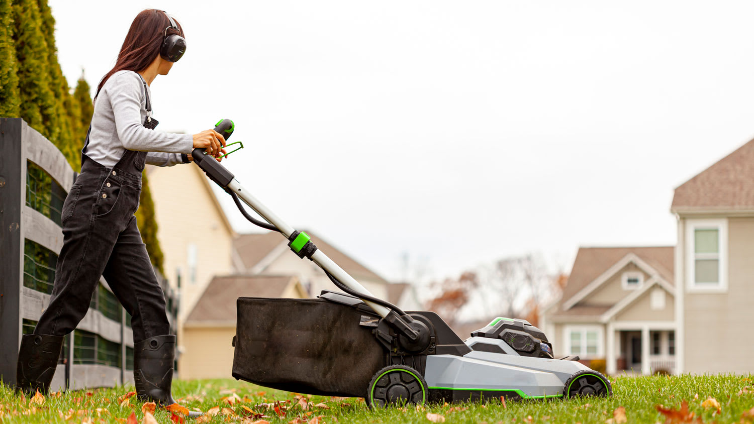 A woman mowing the lawn in late autumn