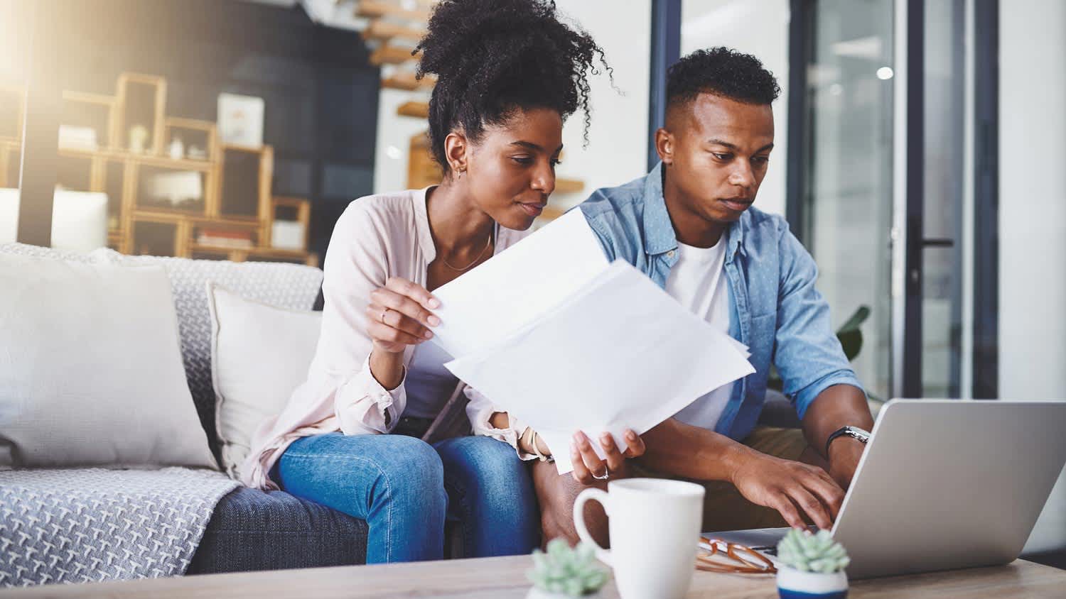 A young couple bidding on a house from a laptop