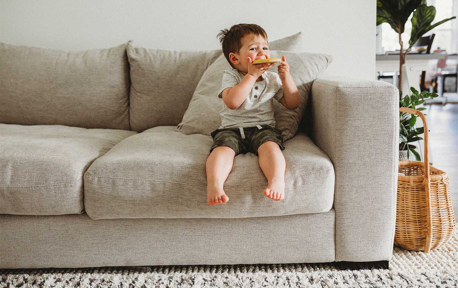 Boy sitting on the sofa eating a snack