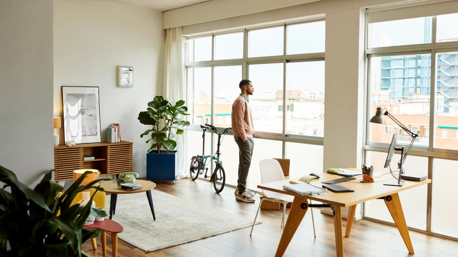 A man looking through the window at home