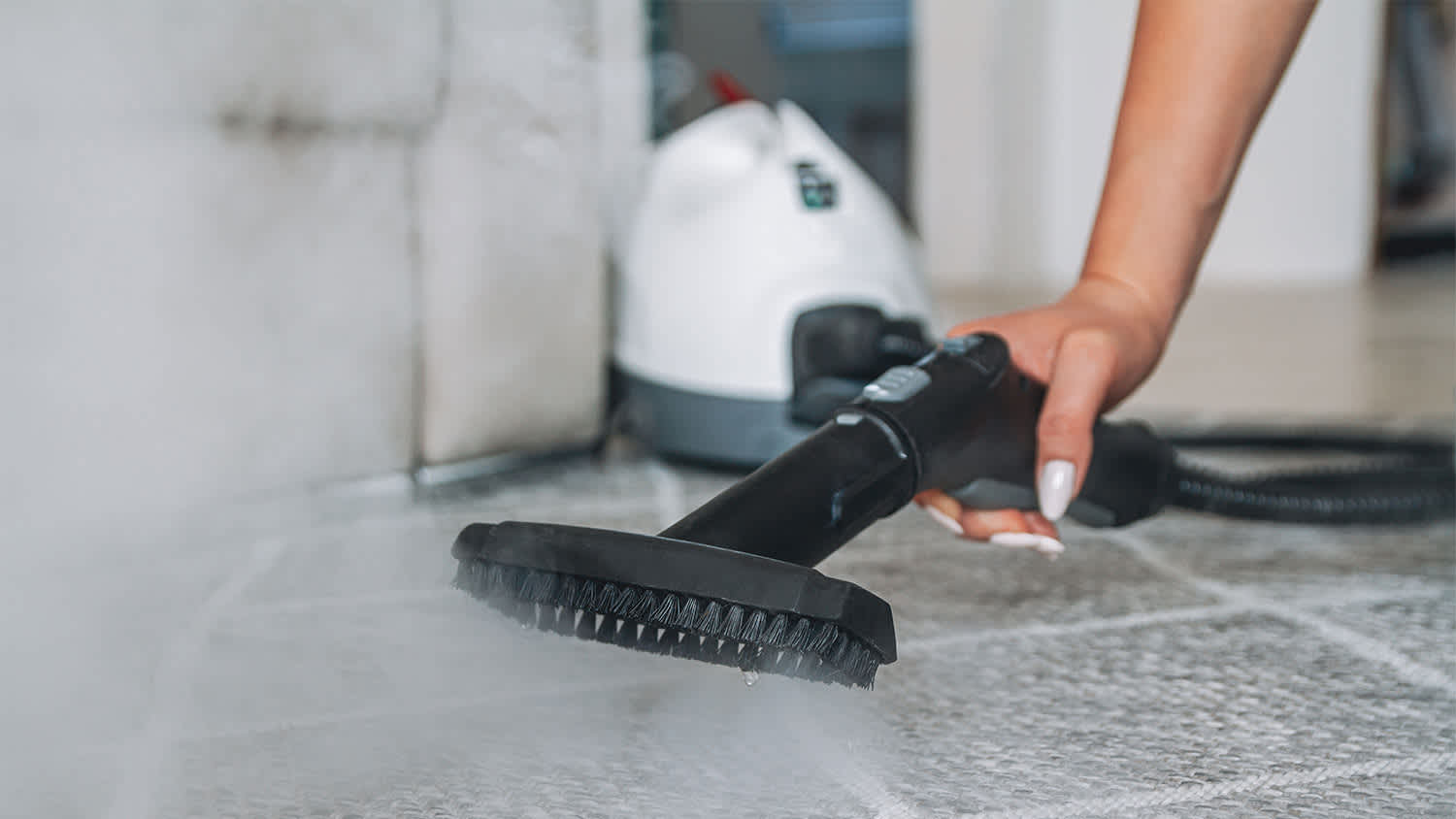 woman cleaning carpet with handheld cleaner