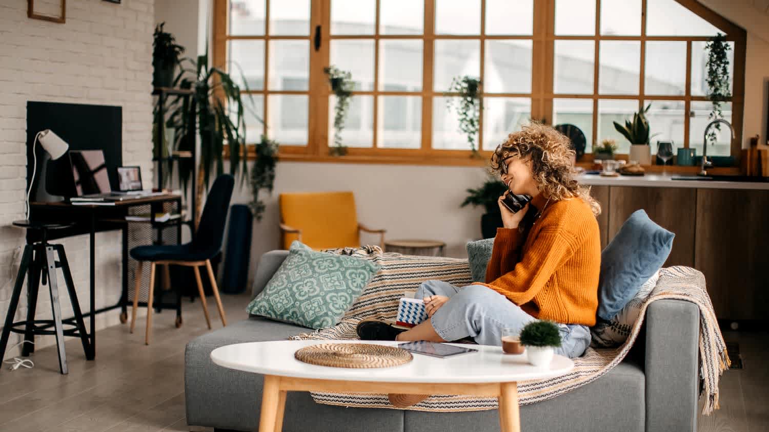 A woman using her cellphone while relaxing at home